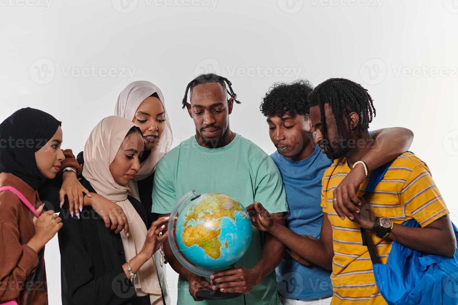 A diverse group of students is gathered around a globe, engrossed in exploration and study, their vibrant energy captured against a pristine white background, symbolizing unity and curiosity in their photo