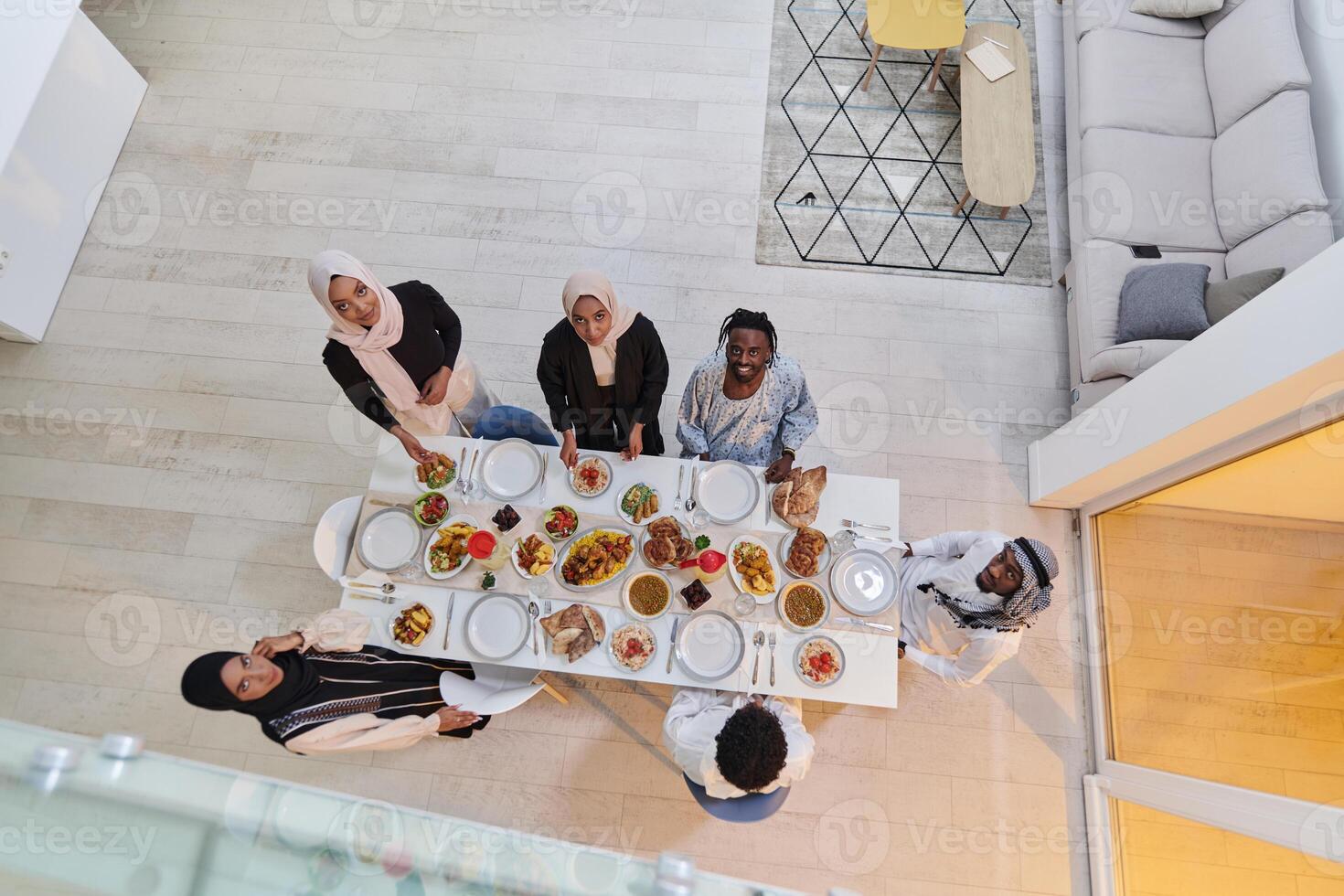 Top view of a Muslim family joyously comes together around a table, eagerly awaiting the communal iftar, engaging in the preparation of a shared meal, and uniting in anticipation of a collective photo