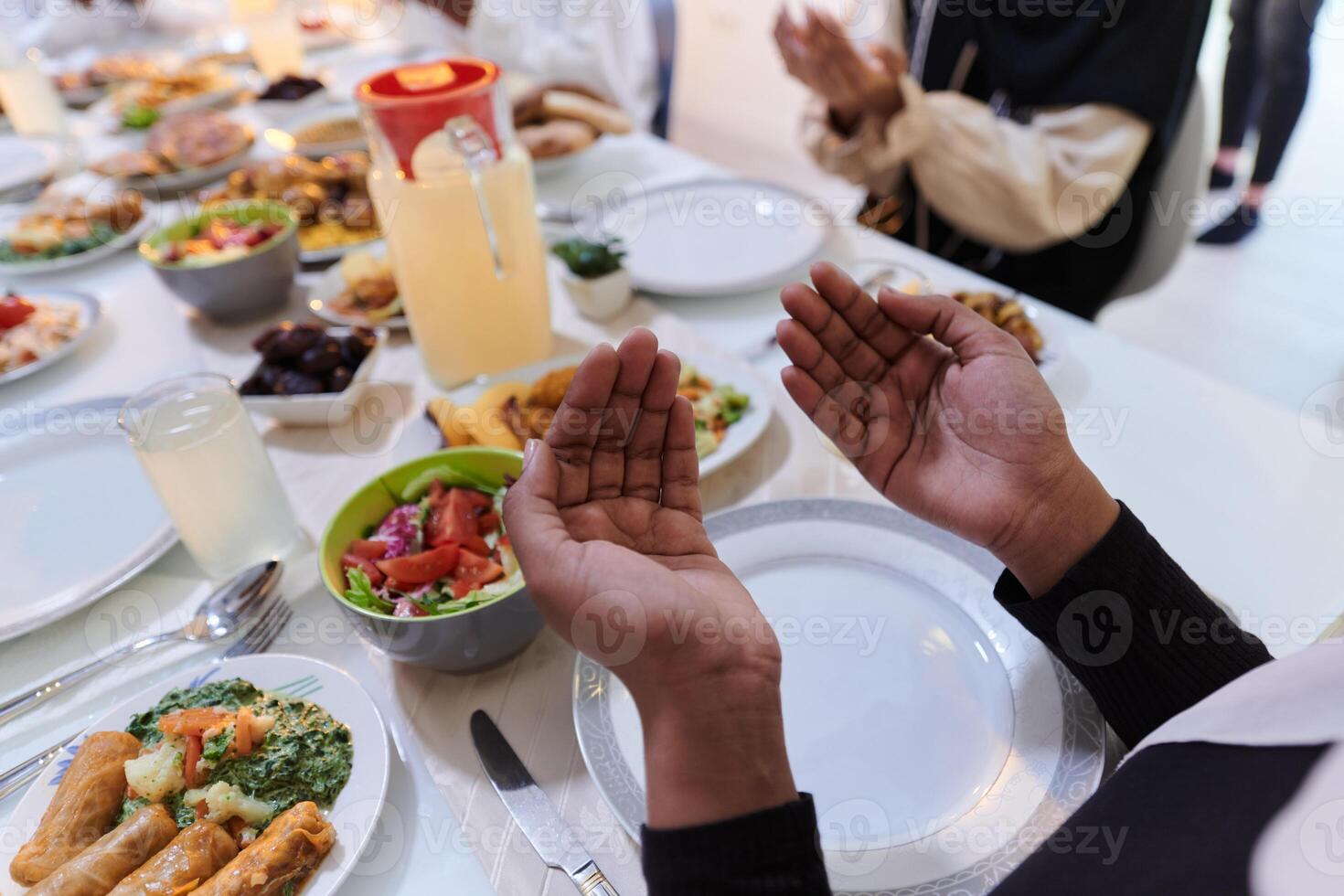 In the sacred month of Ramadan, a diverse Muslim family comes together in spiritual unity, fervently praying to God before breaking their fast, capturing a moment of collective devotion, cultural photo