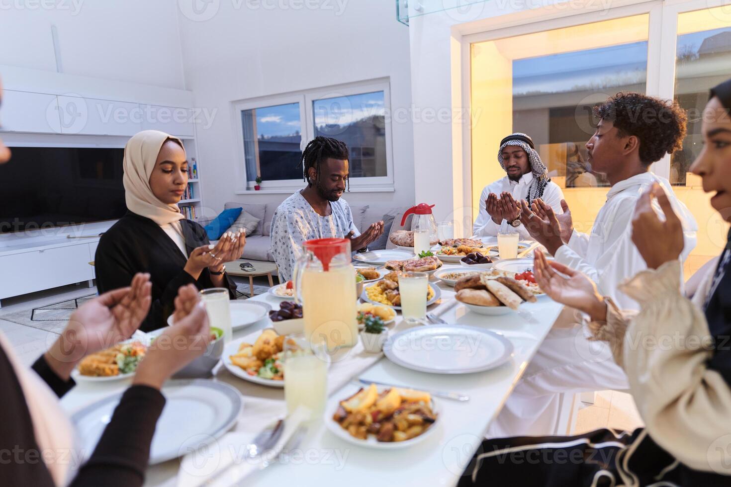 In the sacred month of Ramadan, a diverse Muslim family comes together in spiritual unity, fervently praying to God before breaking their fast, capturing a moment of collective devotion, cultural photo