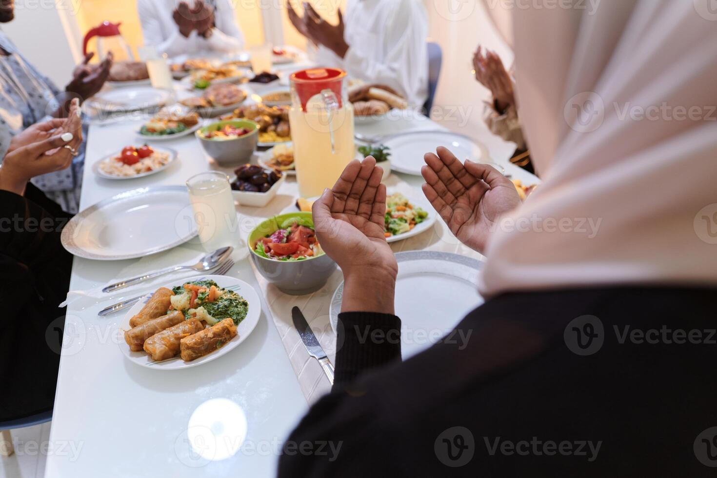 In the sacred month of Ramadan, a diverse Muslim family comes together in spiritual unity, fervently praying to God before breaking their fast, capturing a moment of collective devotion, cultural photo