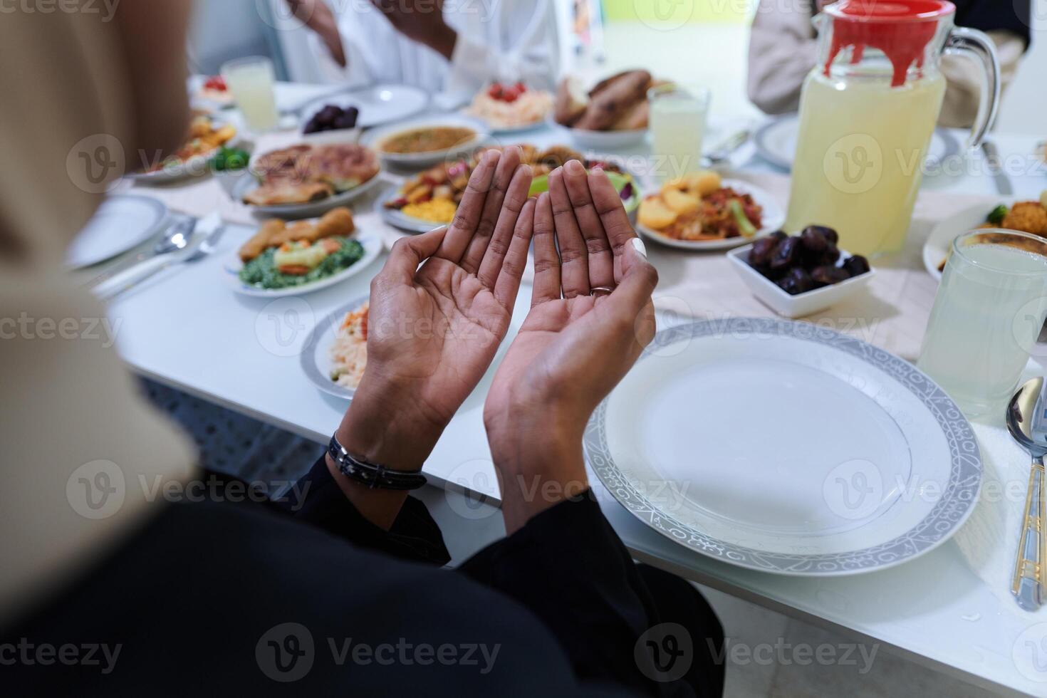 In the sacred month of Ramadan, a diverse Muslim family comes together in spiritual unity, fervently praying to God before breaking their fast, capturing a moment of collective devotion, cultural photo