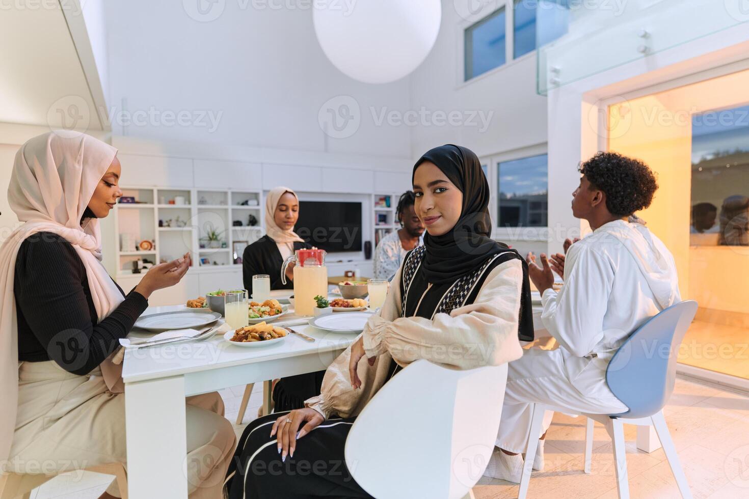 In the sacred month of Ramadan, a diverse Muslim family comes together in spiritual unity, fervently praying to God before breaking their fast, capturing a moment of collective devotion, cultural photo