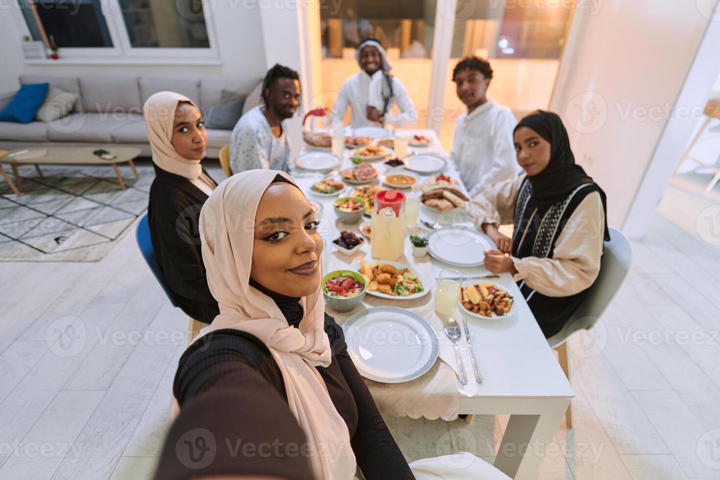 A traditional Muslim family captures the joy of their shared iftar meal during the sacred month of Ramadan through a cheerful family selfie, blending cultural richness, familial togetherness, and the photo