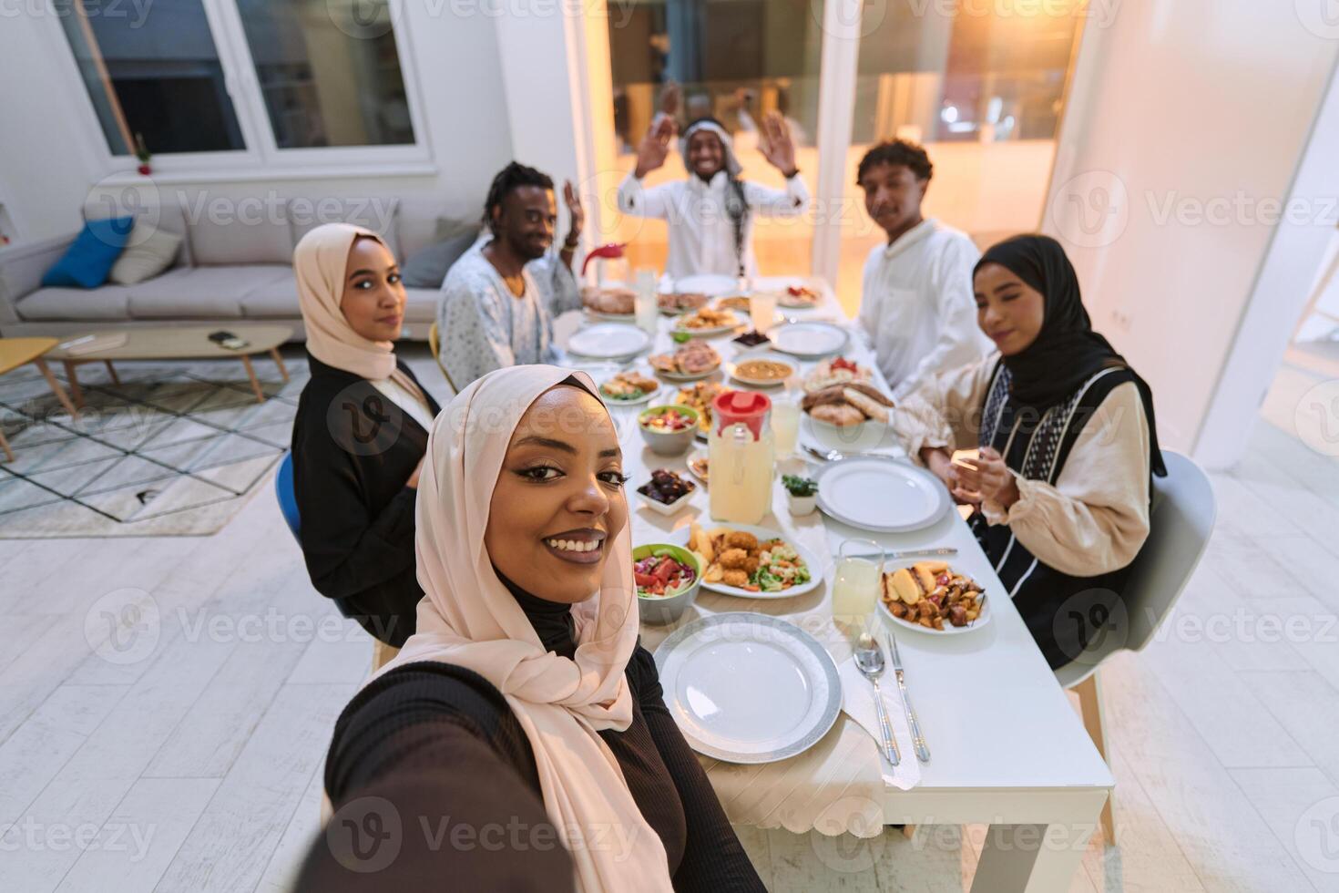 A traditional Muslim family captures the joy of their shared iftar meal during the sacred month of Ramadan through a cheerful family selfie, blending cultural richness, familial togetherness, and the photo