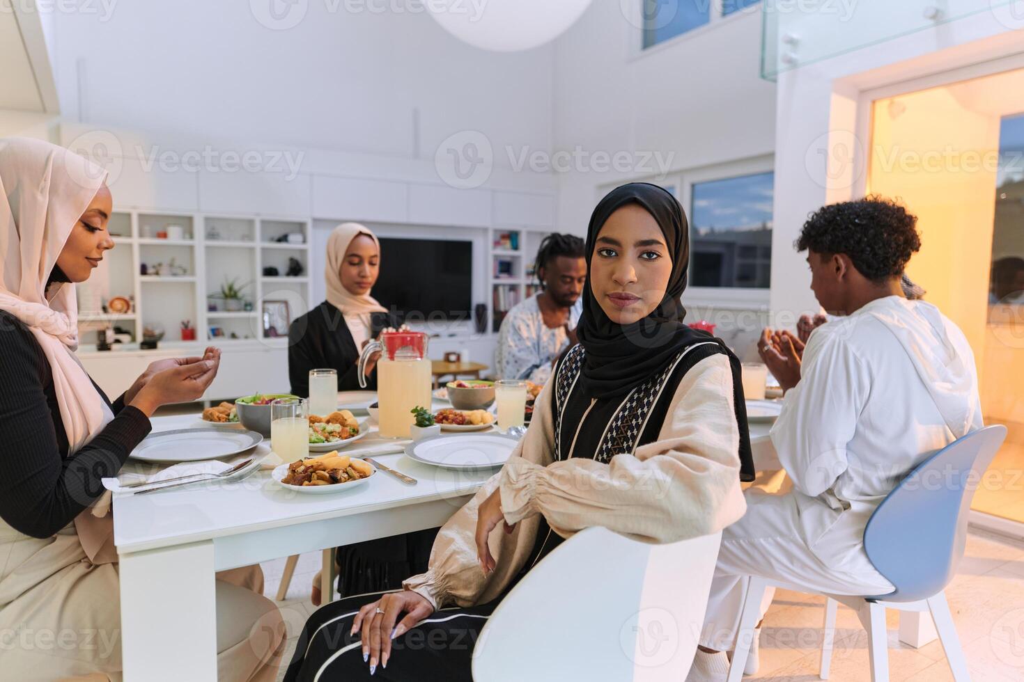 In the sacred month of Ramadan, a diverse Muslim family comes together in spiritual unity, fervently praying to God before breaking their fast, capturing a moment of collective devotion, cultural photo