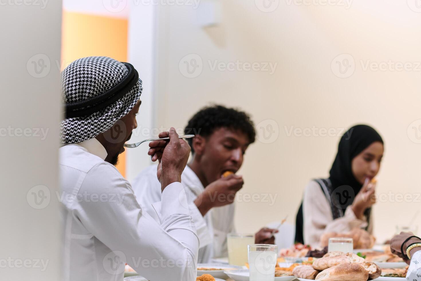 A traditional and diverse Muslim family comes together to share a delicious iftar meal during the sacred month of Ramadan, embodying the essence of familial joy, cultural richness, and spiritual unity photo