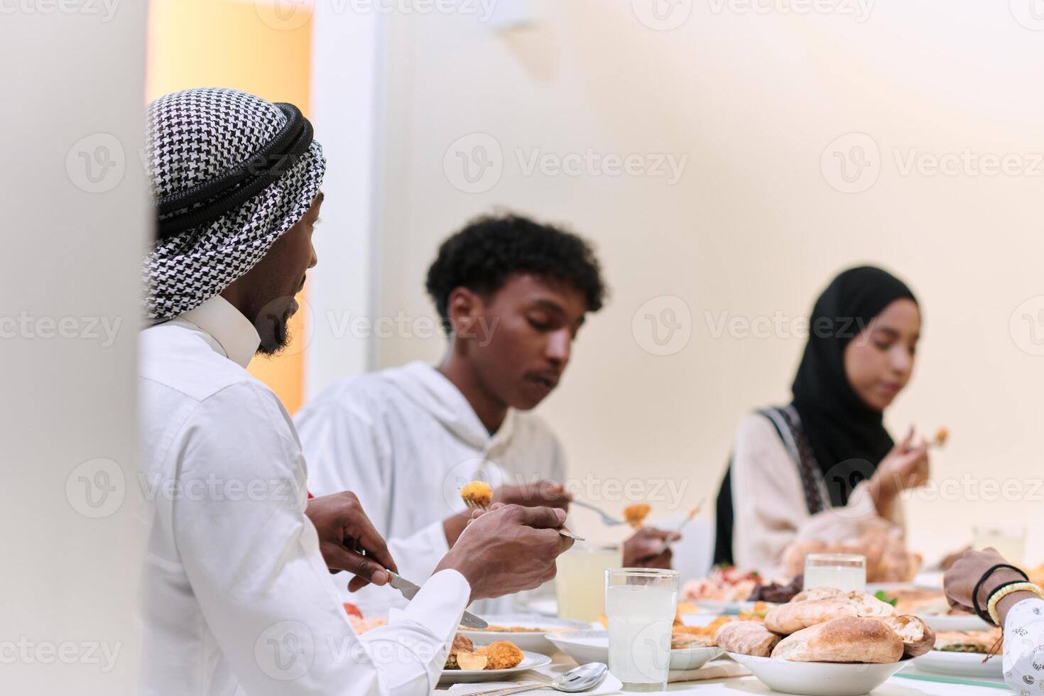 A traditional and diverse Muslim family comes together to share a delicious iftar meal during the sacred month of Ramadan, embodying the essence of familial joy, cultural richness, and spiritual unity photo