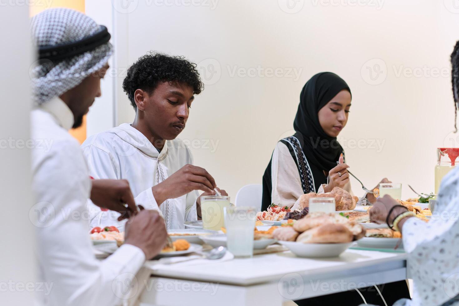 A traditional and diverse Muslim family comes together to share a delicious iftar meal during the sacred month of Ramadan, embodying the essence of familial joy, cultural richness, and spiritual unity photo