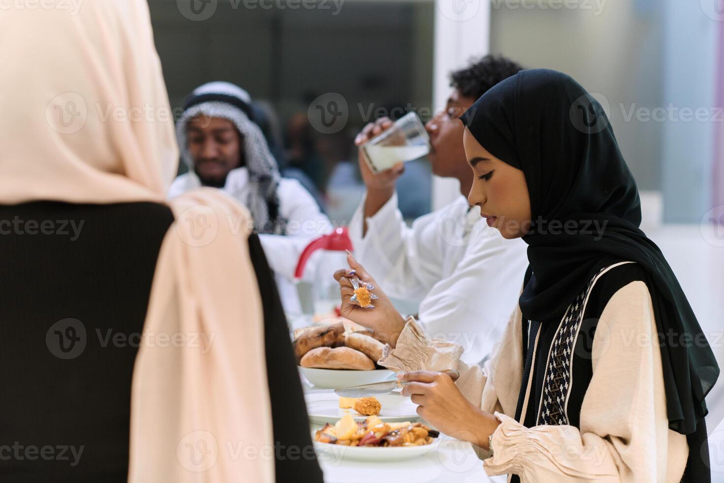 A traditional and diverse Muslim family comes together to share a delicious iftar meal during the sacred month of Ramadan, embodying the essence of familial joy, cultural richness, and spiritual unity photo