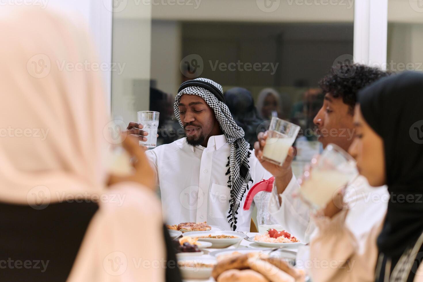 A traditional and diverse Muslim family comes together to share a delicious iftar meal during the sacred month of Ramadan, embodying the essence of familial joy, cultural richness, and spiritual unity photo