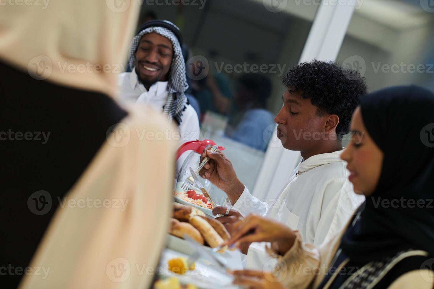 A traditional and diverse Muslim family comes together to share a delicious iftar meal during the sacred month of Ramadan, embodying the essence of familial joy, cultural richness, and spiritual unity photo