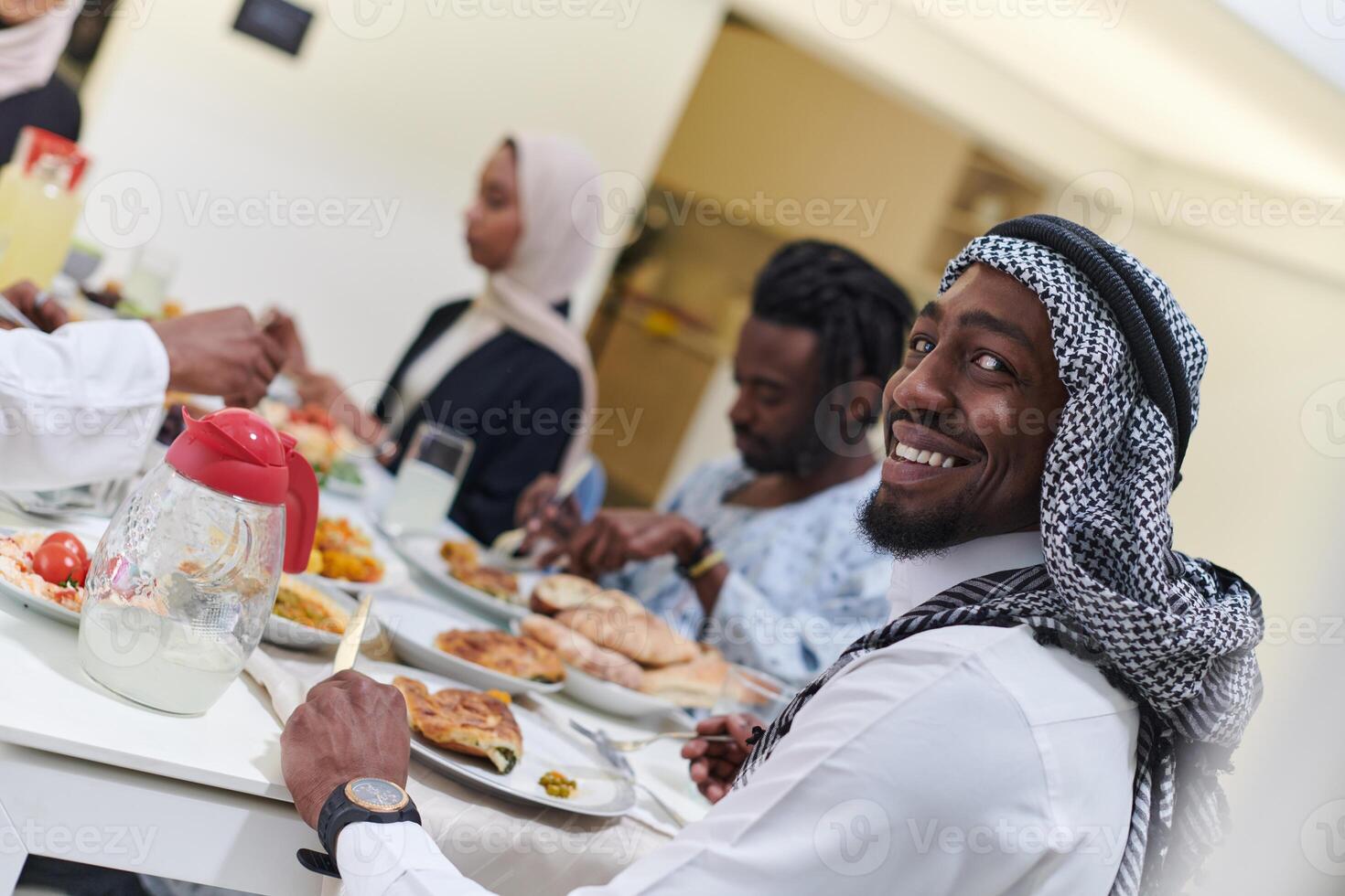 A traditional and diverse Muslim family comes together to share a delicious iftar meal during the sacred month of Ramadan, embodying the essence of familial joy, cultural richness, and spiritual unity photo