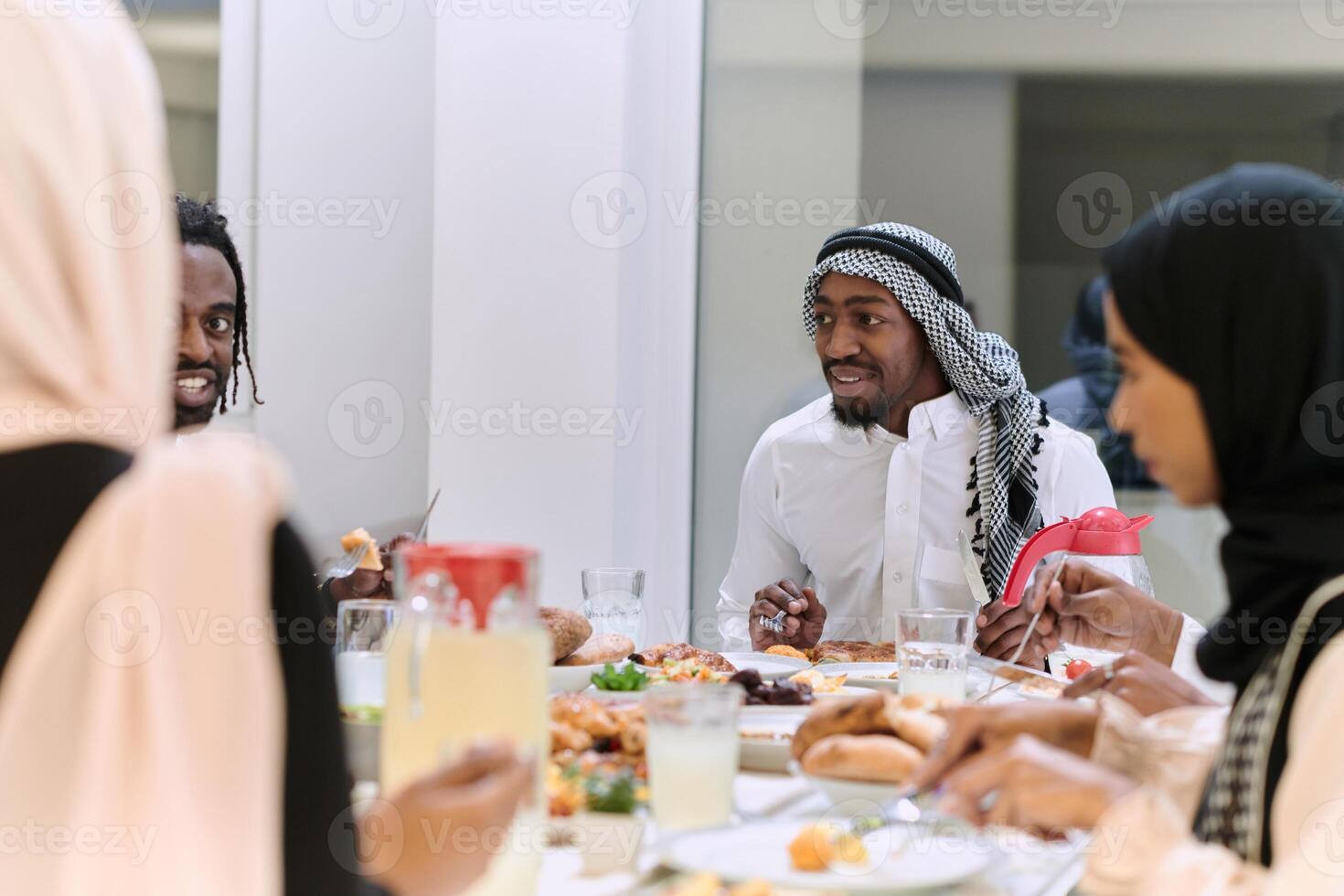 A traditional and diverse Muslim family comes together to share a delicious iftar meal during the sacred month of Ramadan, embodying the essence of familial joy, cultural richness, and spiritual unity photo