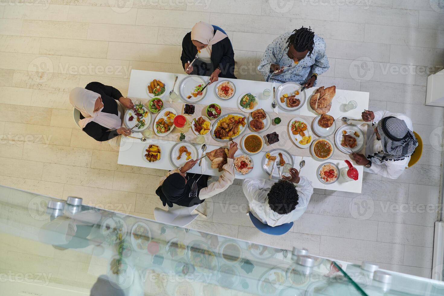 Top view of traditional and diverse Muslim family comes together to share a delicious iftar meal during the sacred month of Ramadan, embodying the essence of familial joy, cultural richness, and photo
