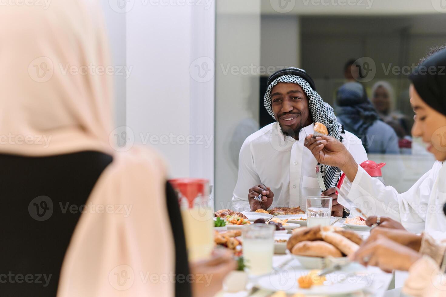 A traditional and diverse Muslim family comes together to share a delicious iftar meal during the sacred month of Ramadan, embodying the essence of familial joy, cultural richness, and spiritual unity photo