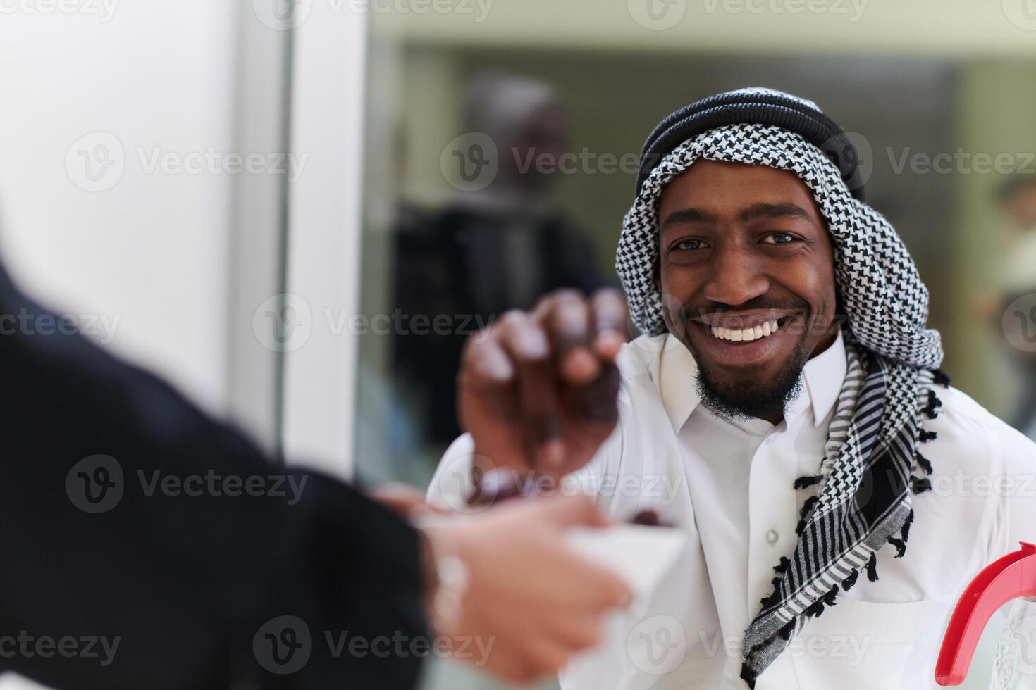 African American Muslim man delicately takes dates to break his fast during the Ramadan month, seated at the family dinner table, embodying a scene of spiritual reflection, cultural tradition, and the photo