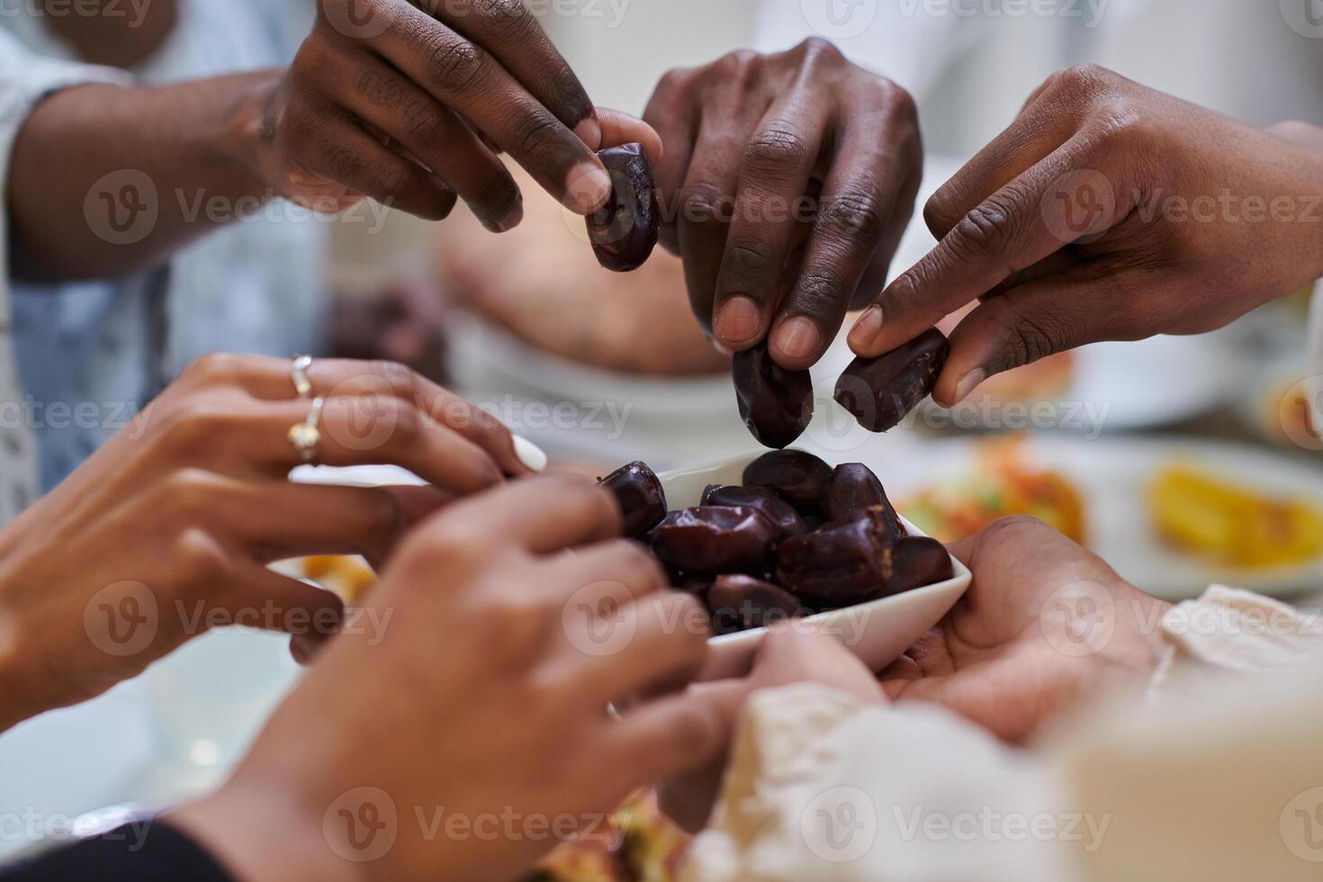 In a poignant close-up, the diverse hands of a Muslim family delicately grasp fresh dates, symbolizing the breaking of the fast during the holy month of Ramadan, capturing a moment of cultural unity photo