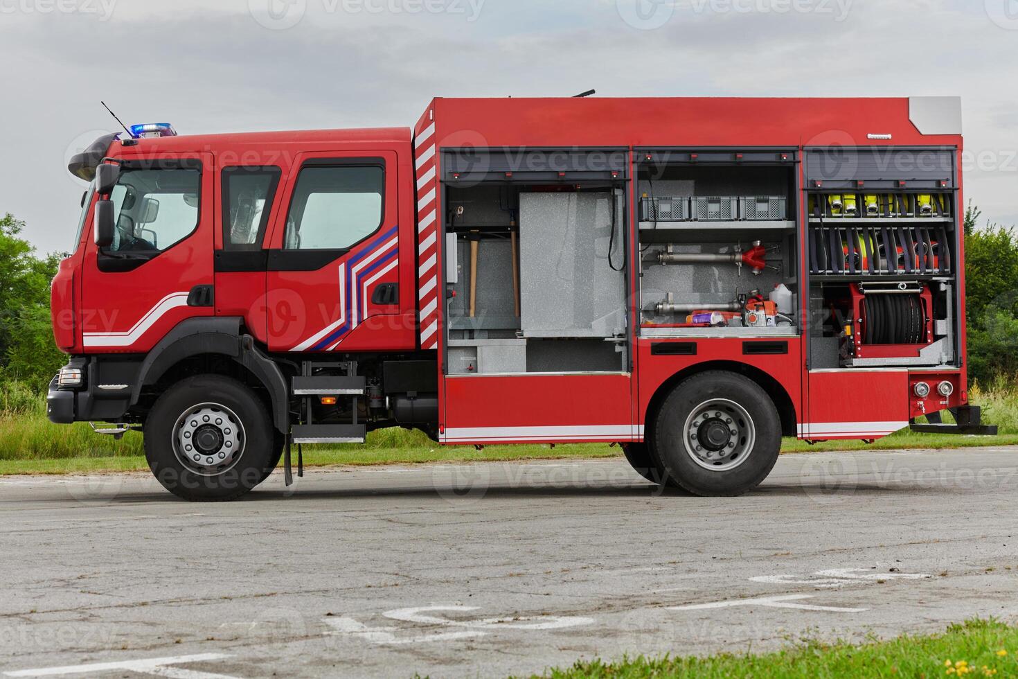 In this captivating scene, a state-of-the-art firetruck, equipped with advanced rescue technology, stands ready with its skilled firefighting team, prepared to intervene and respond rapidly to photo