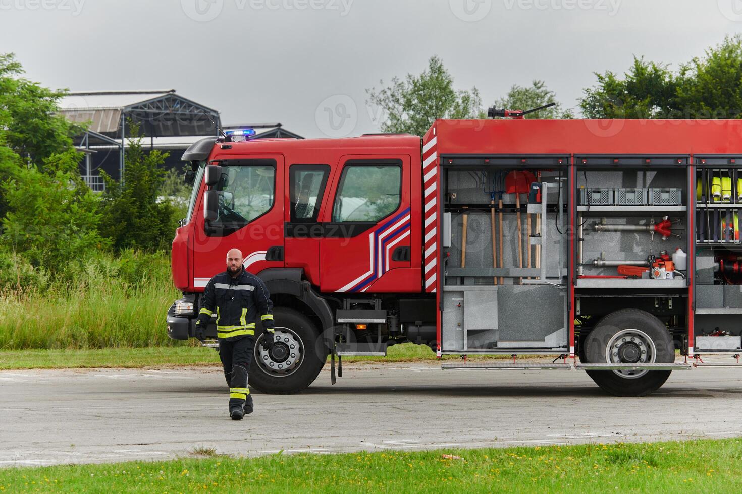 A firefighter meticulously prepares a modern firetruck for a mission to evacuate and respond to dangerous situations, showcasing the utmost dedication to safety and readiness in the face of a fire photo