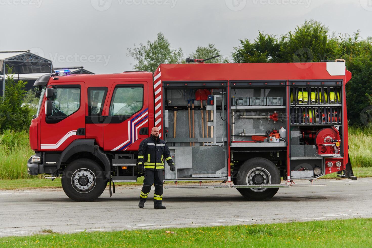 A firefighter meticulously prepares a modern firetruck for a mission to evacuate and respond to dangerous situations, showcasing the utmost dedication to safety and readiness in the face of a fire photo