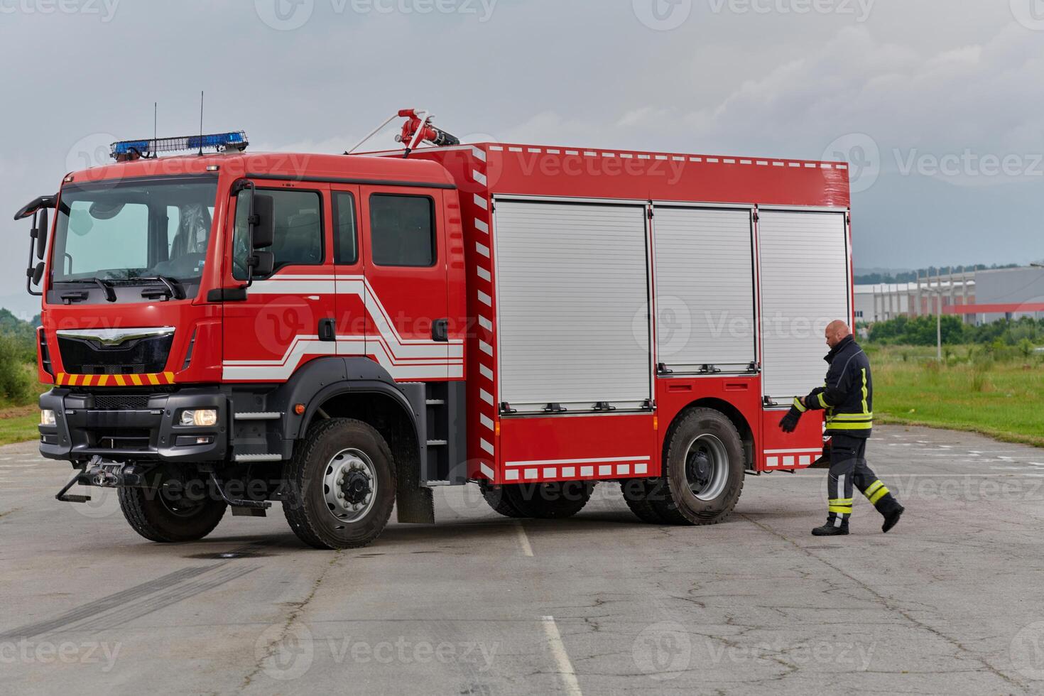 A firefighter meticulously prepares a modern firetruck for a mission to evacuate and respond to dangerous situations, showcasing the utmost dedication to safety and readiness in the face of a fire photo