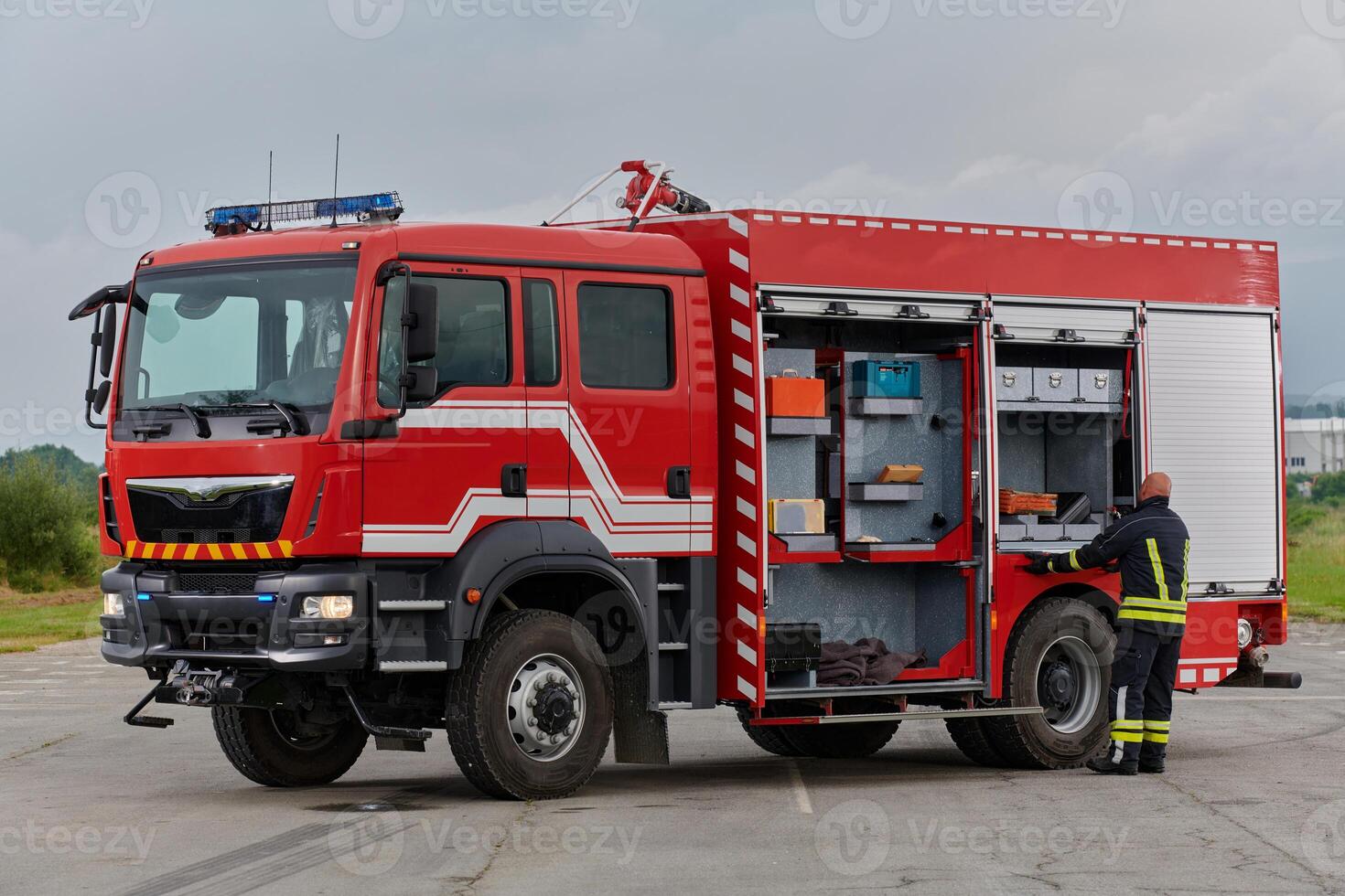 A firefighter meticulously prepares a modern firetruck for a mission to evacuate and respond to dangerous situations, showcasing the utmost dedication to safety and readiness in the face of a fire photo