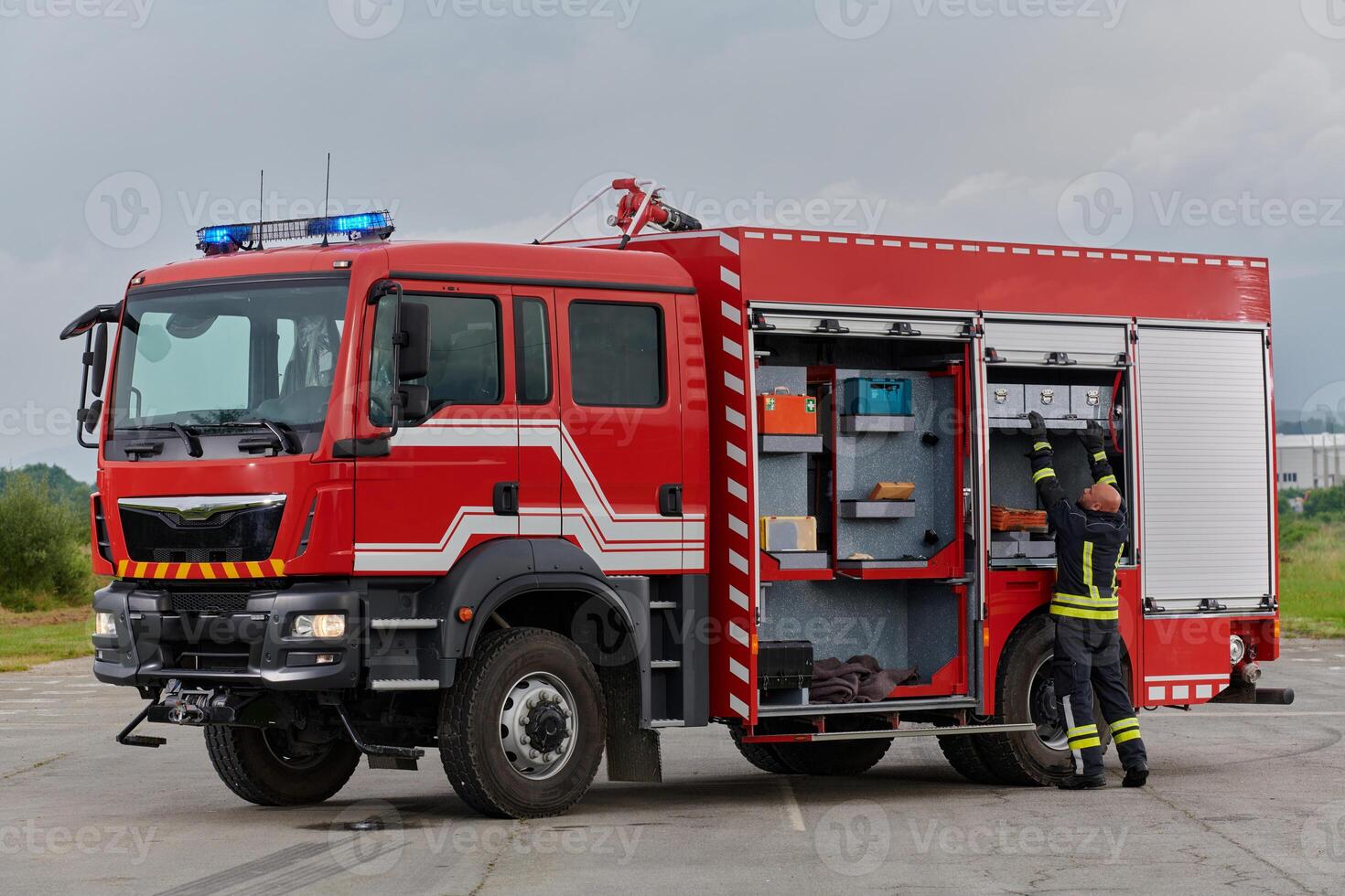 A firefighter meticulously prepares a modern firetruck for a mission to evacuate and respond to dangerous situations, showcasing the utmost dedication to safety and readiness in the face of a fire photo