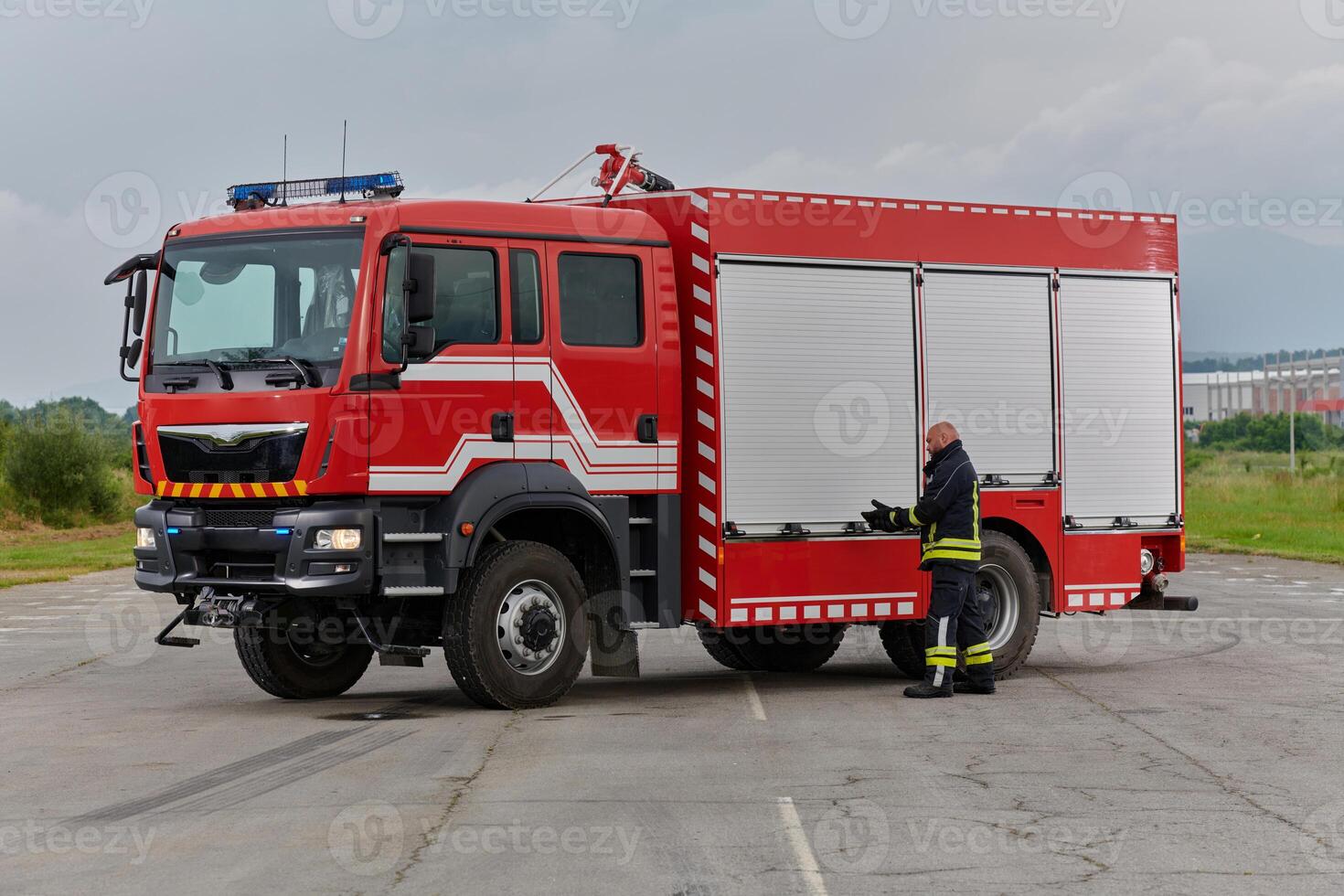 A firefighter meticulously prepares a modern firetruck for a mission to evacuate and respond to dangerous situations, showcasing the utmost dedication to safety and readiness in the face of a fire photo