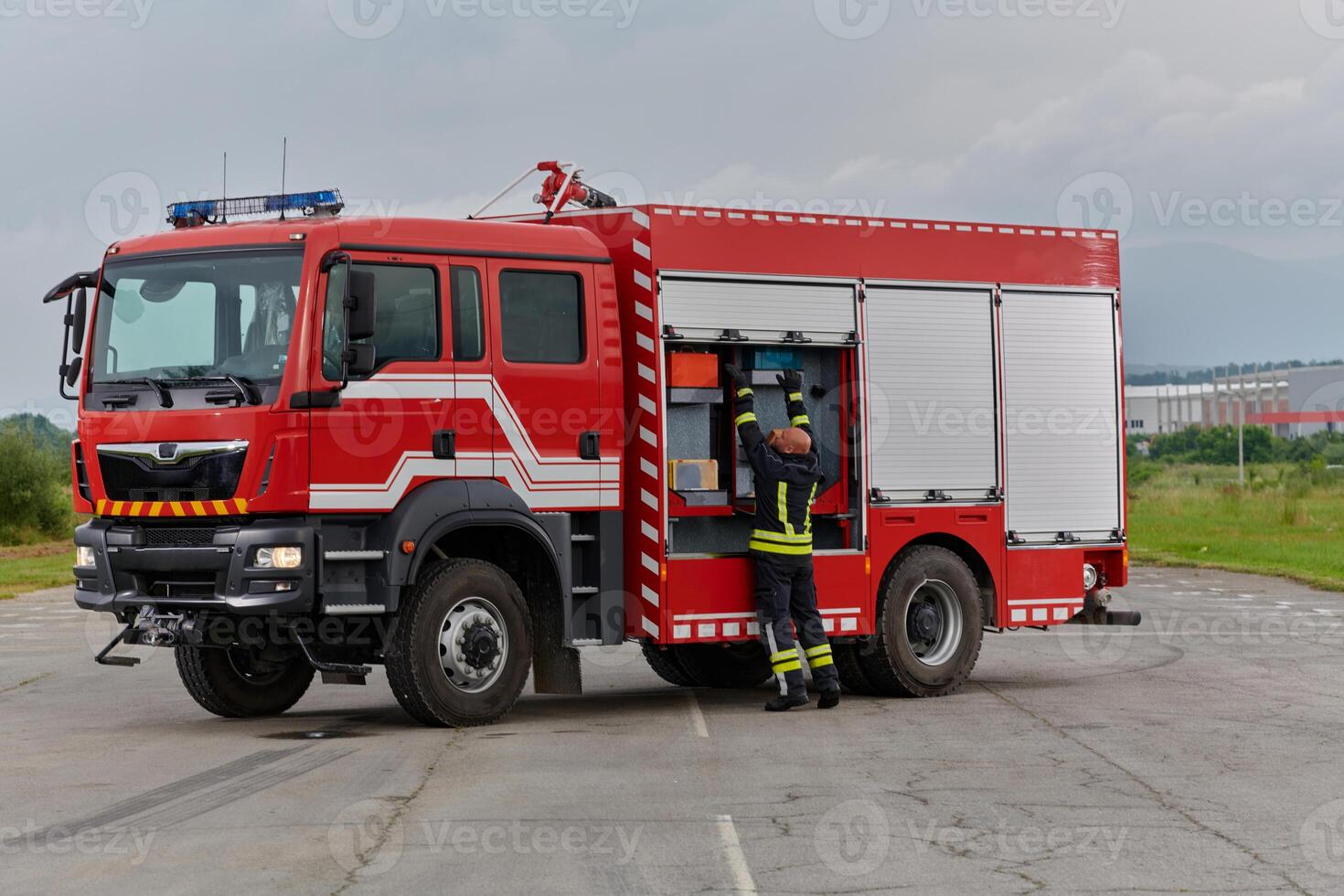 A firefighter meticulously prepares a modern firetruck for a mission to evacuate and respond to dangerous situations, showcasing the utmost dedication to safety and readiness in the face of a fire photo