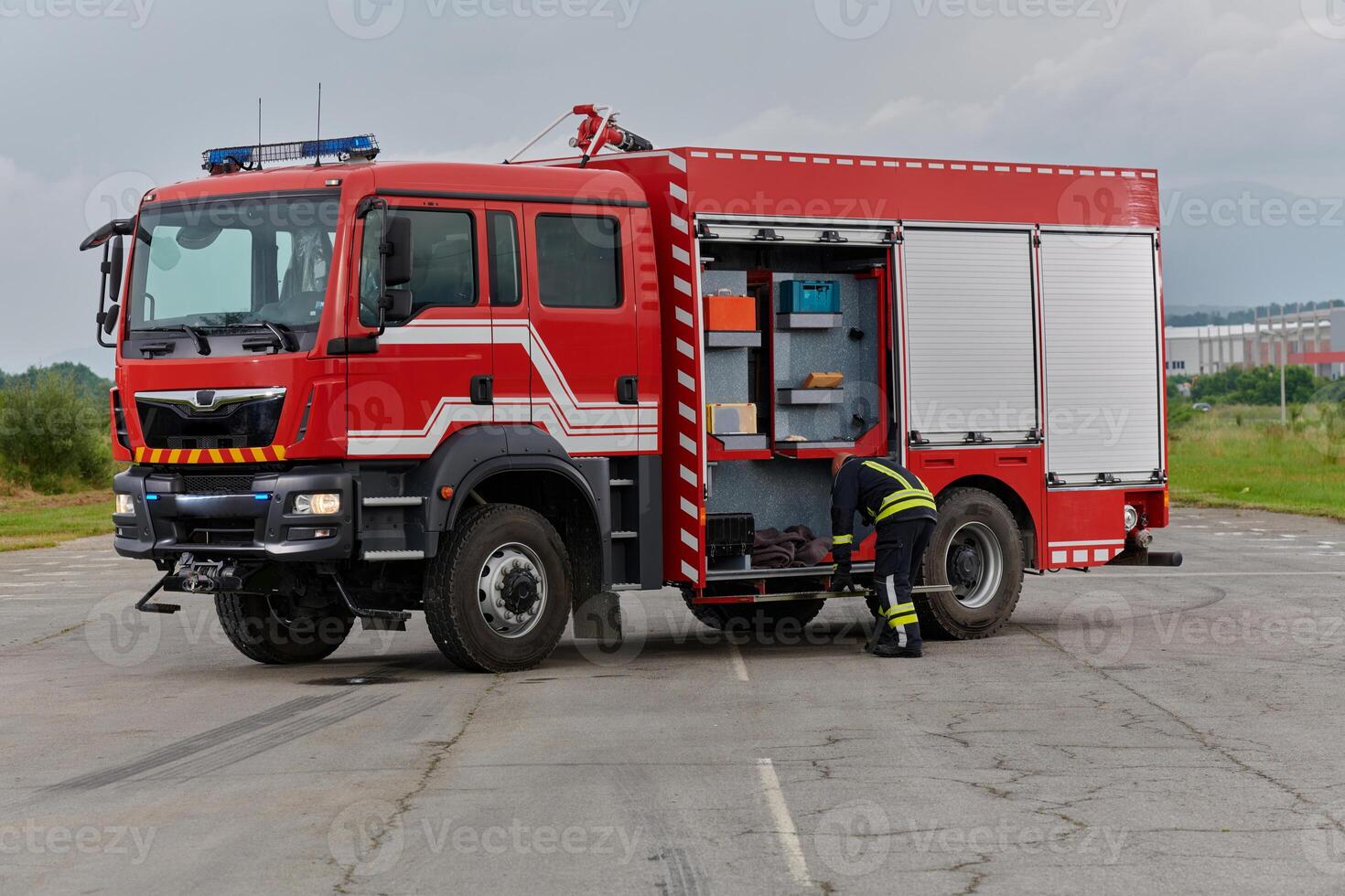 A firefighter meticulously prepares a modern firetruck for a mission to evacuate and respond to dangerous situations, showcasing the utmost dedication to safety and readiness in the face of a fire photo