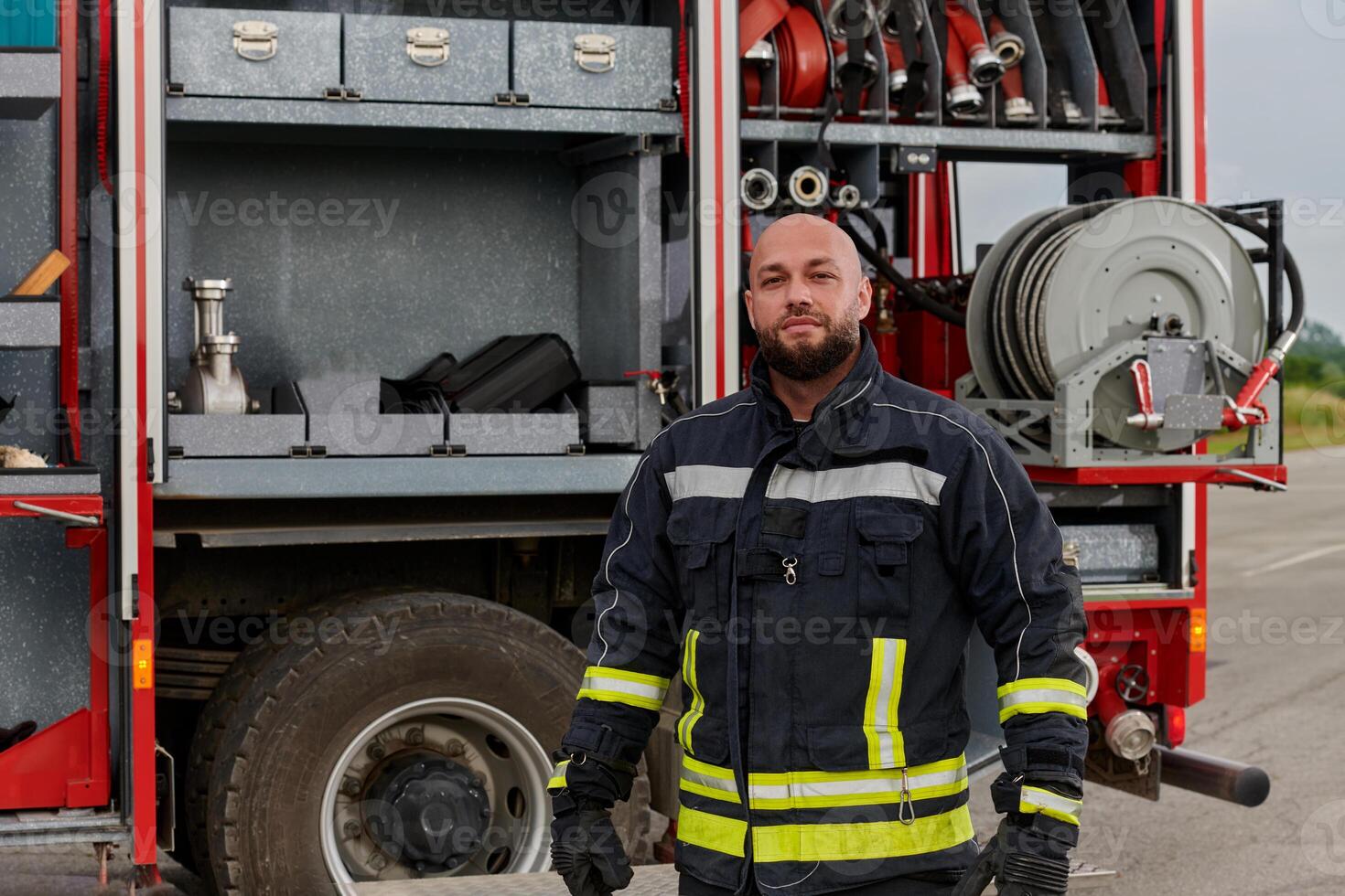 A firefighter meticulously prepares a modern firetruck for a mission to evacuate and respond to dangerous situations, showcasing the utmost dedication to safety and readiness in the face of a fire photo