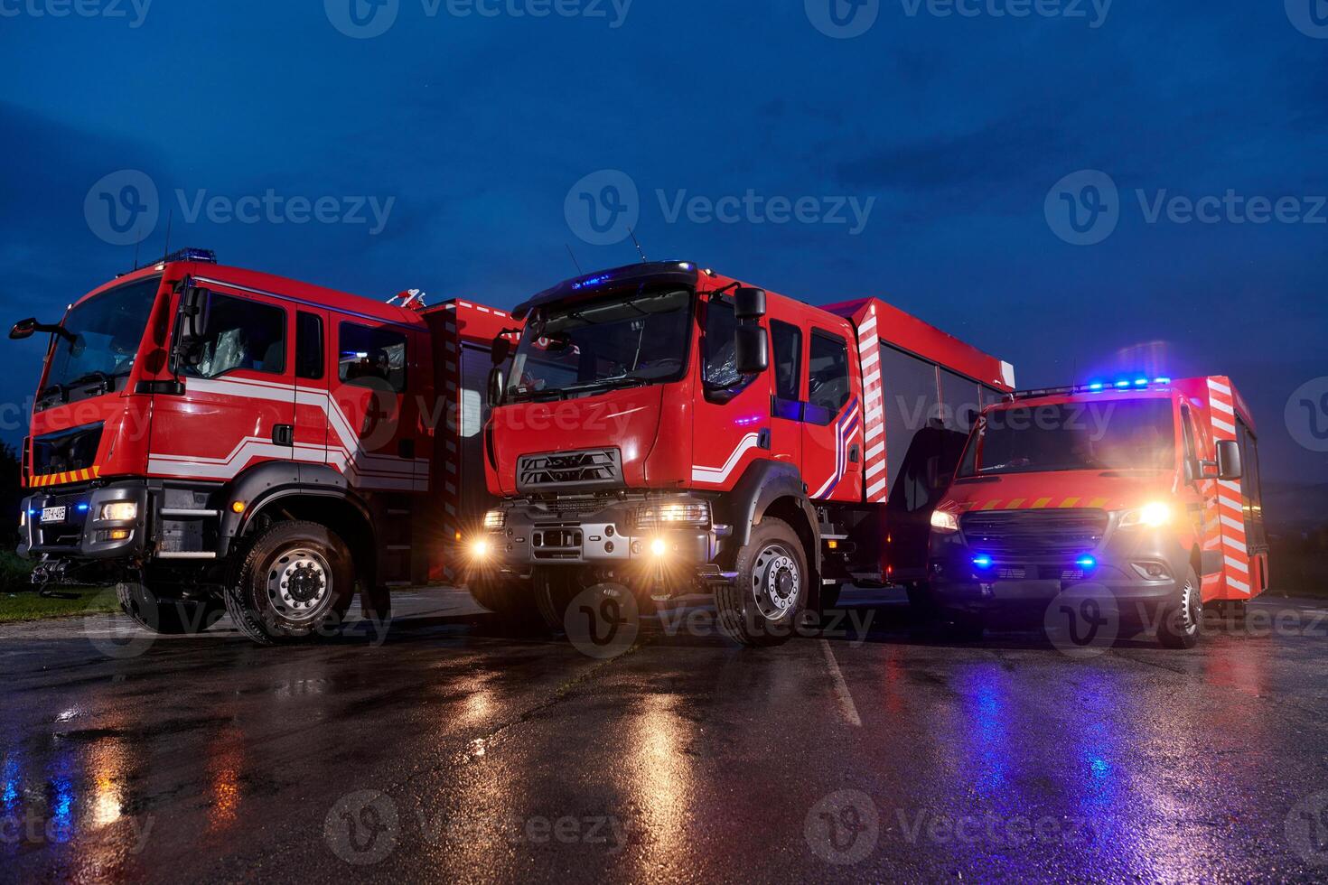 A pair of highly modern and quality fire trucks illuminate the night with their rotating lights, symbolizing the cutting-edge technology and preparedness of the firefighting fleet, ready to respond to photo