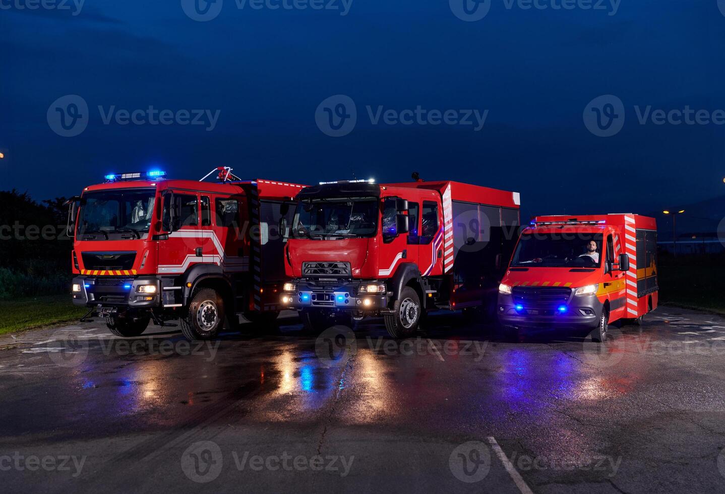 A pair of highly modern and quality fire trucks illuminate the night with their rotating lights, symbolizing the cutting-edge technology and preparedness of the firefighting fleet, ready to respond to photo
