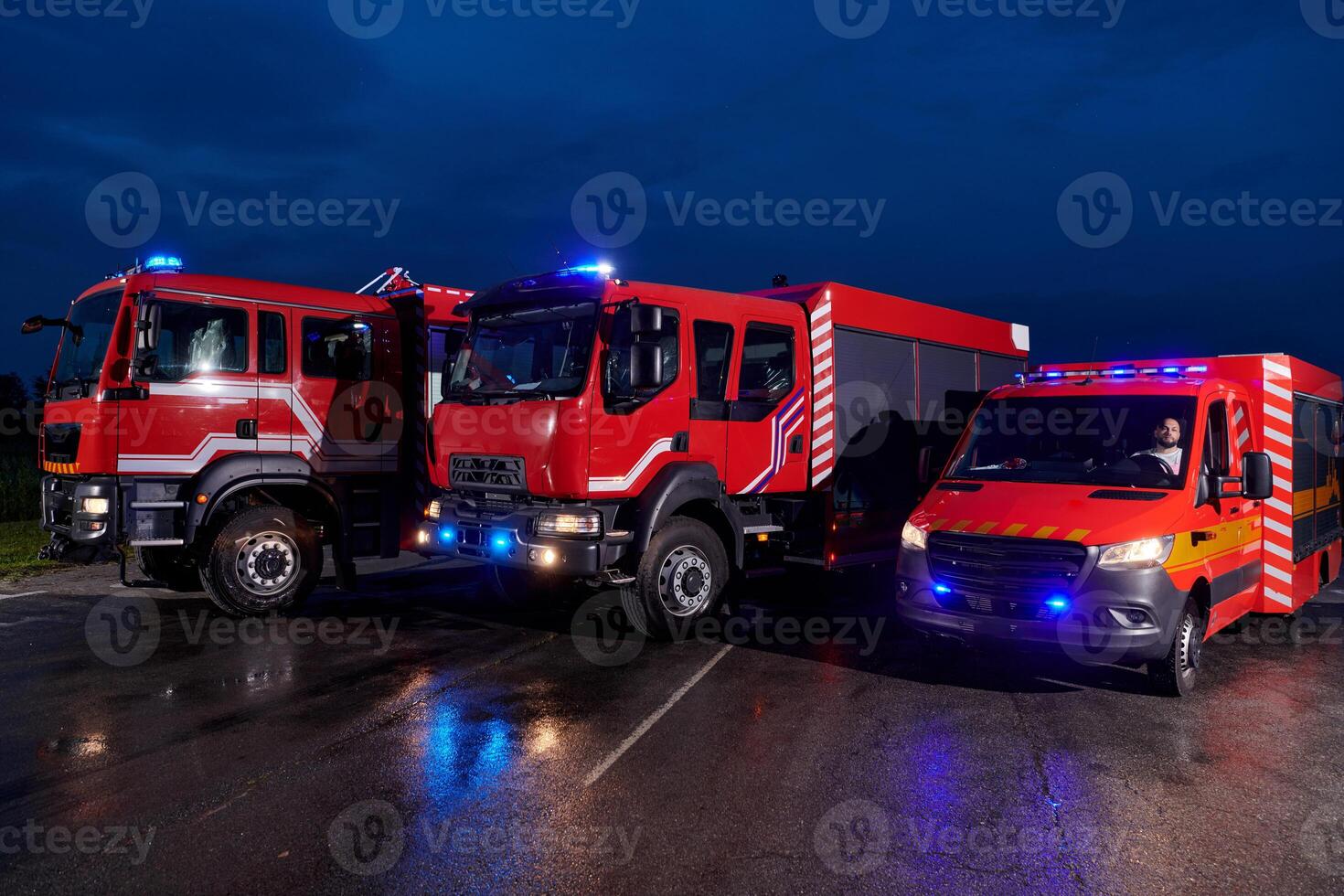 A pair of highly modern and quality fire trucks illuminate the night with their rotating lights, symbolizing the cutting-edge technology and preparedness of the firefighting fleet, ready to respond to photo