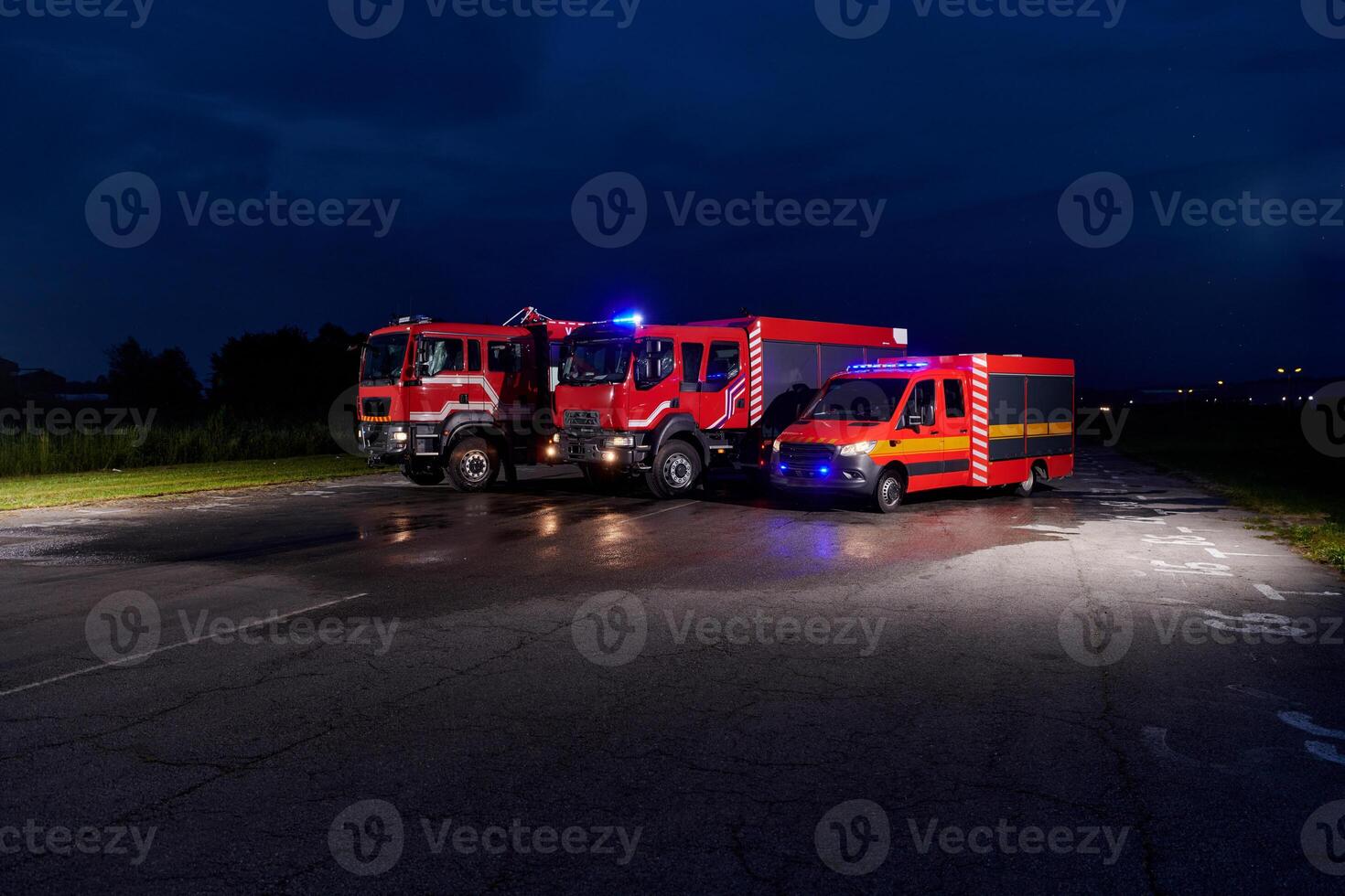 A pair of highly modern and quality fire trucks illuminate the night with their rotating lights, symbolizing the cutting-edge technology and preparedness of the firefighting fleet, ready to respond to photo