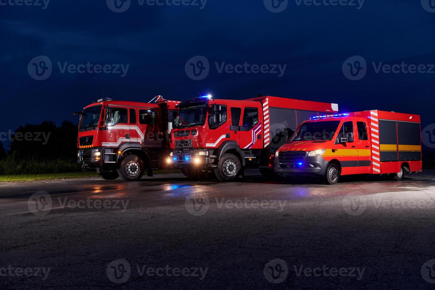 A pair of highly modern and quality fire trucks illuminate the night with their rotating lights, symbolizing the cutting-edge technology and preparedness of the firefighting fleet, ready to respond to photo