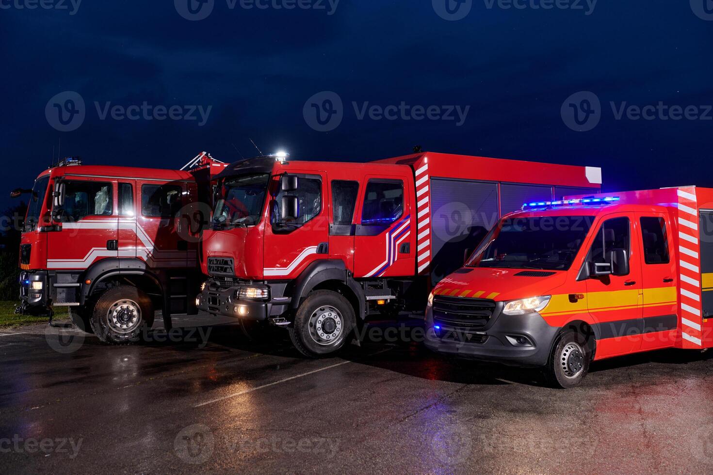 A pair of highly modern and quality fire trucks illuminate the night with their rotating lights, symbolizing the cutting-edge technology and preparedness of the firefighting fleet, ready to respond to photo