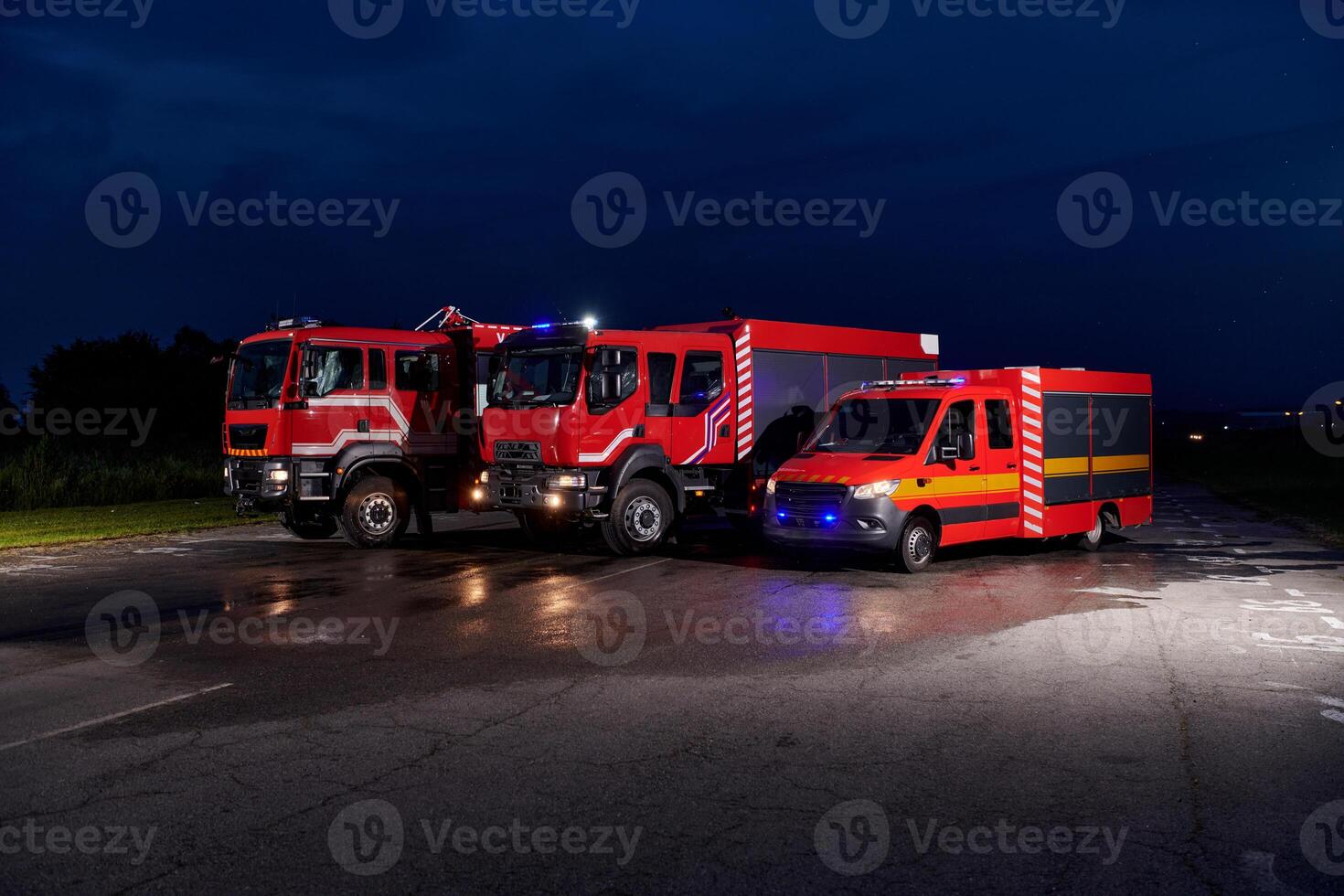 A pair of highly modern and quality fire trucks illuminate the night with their rotating lights, symbolizing the cutting-edge technology and preparedness of the firefighting fleet, ready to respond to photo