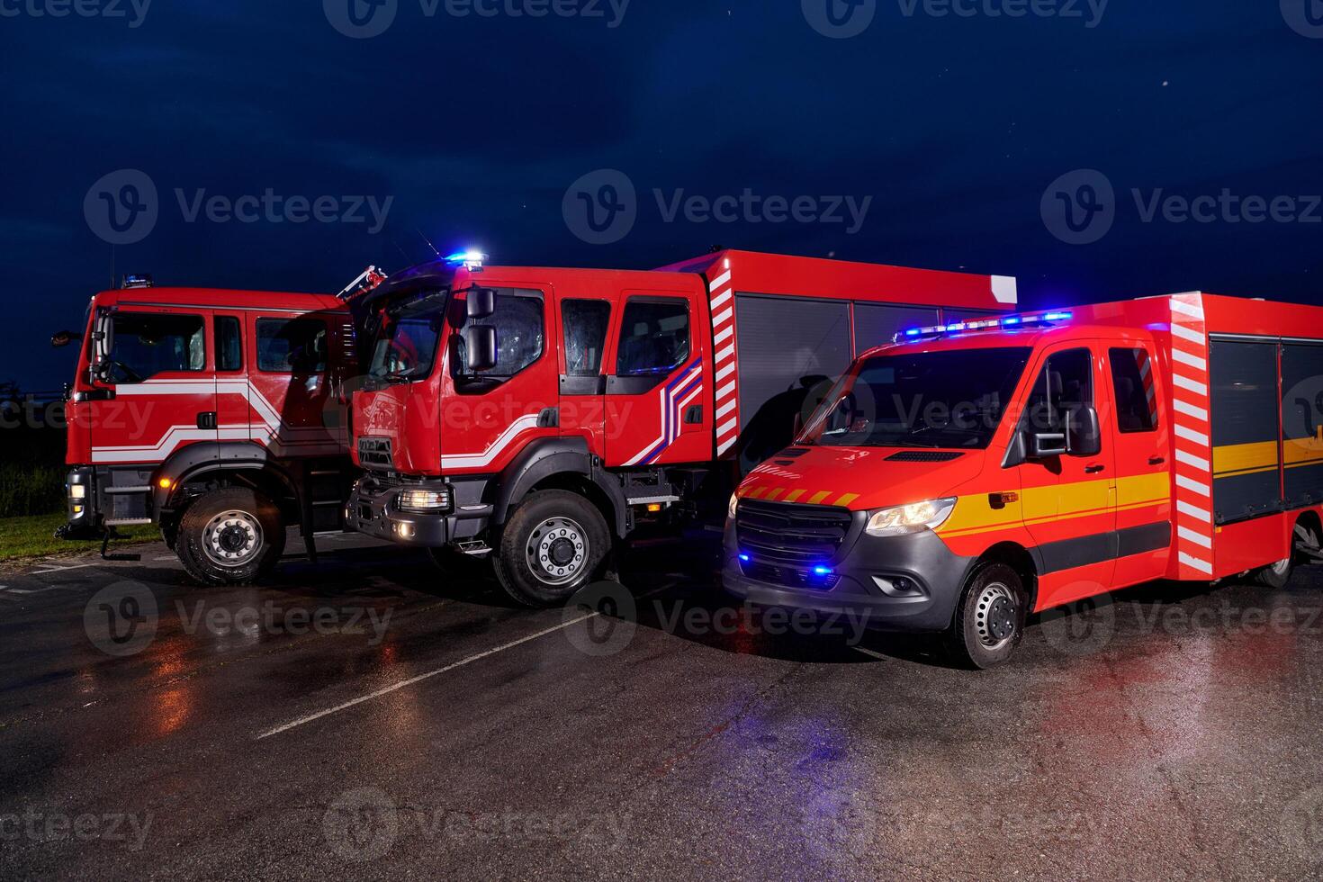 A pair of highly modern and quality fire trucks illuminate the night with their rotating lights, symbolizing the cutting-edge technology and preparedness of the firefighting fleet, ready to respond to photo