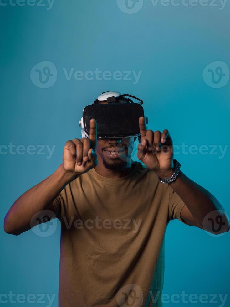 Immersed in a digital realm, an African American man navigates the virtual landscape with a VR goggles, using tactile gestures to interact with virtual objects, showcasing a harmonious blend of photo