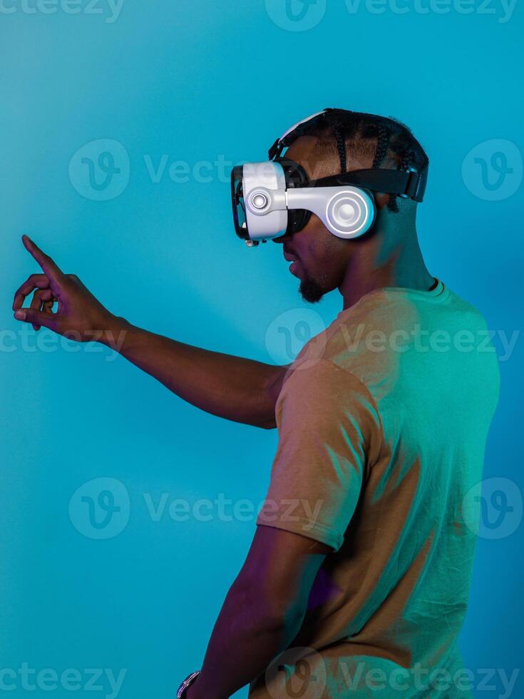 Immersed in a digital realm, an African American man navigates the virtual landscape with a VR goggles, using tactile gestures to interact with virtual objects, showcasing a harmonious blend of photo