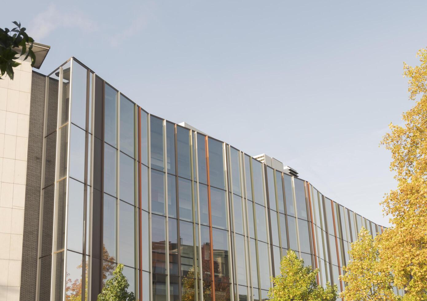 Hasselt, Limburg-Belgium. 23-10-2021. Building with reflective glass on the front. Against the background of the blue autumn sky photo