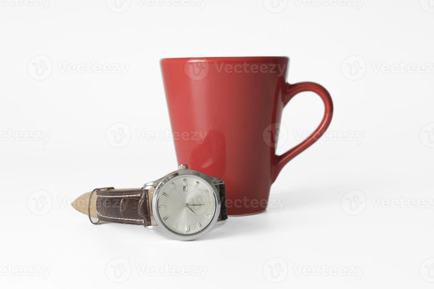 Time for coffee. Red mug and wrist watch on a strap on a white background. mockup, close-up. selected focus on the watch photo