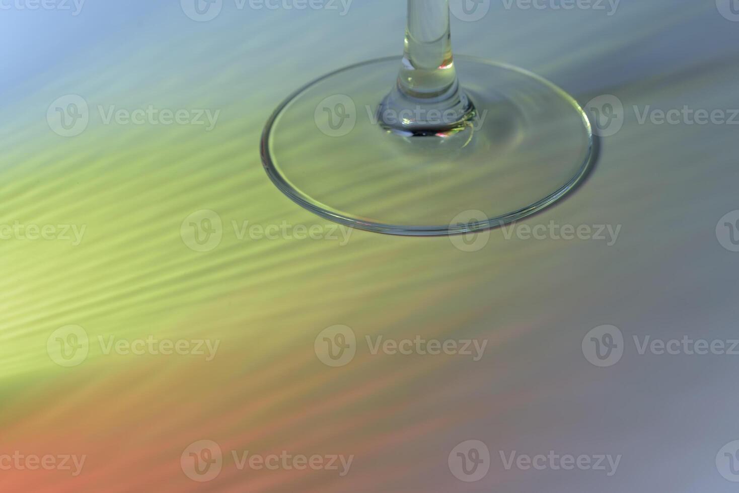 Stem of the glass and falling yellow rays on the purple background.. Copy space photo
