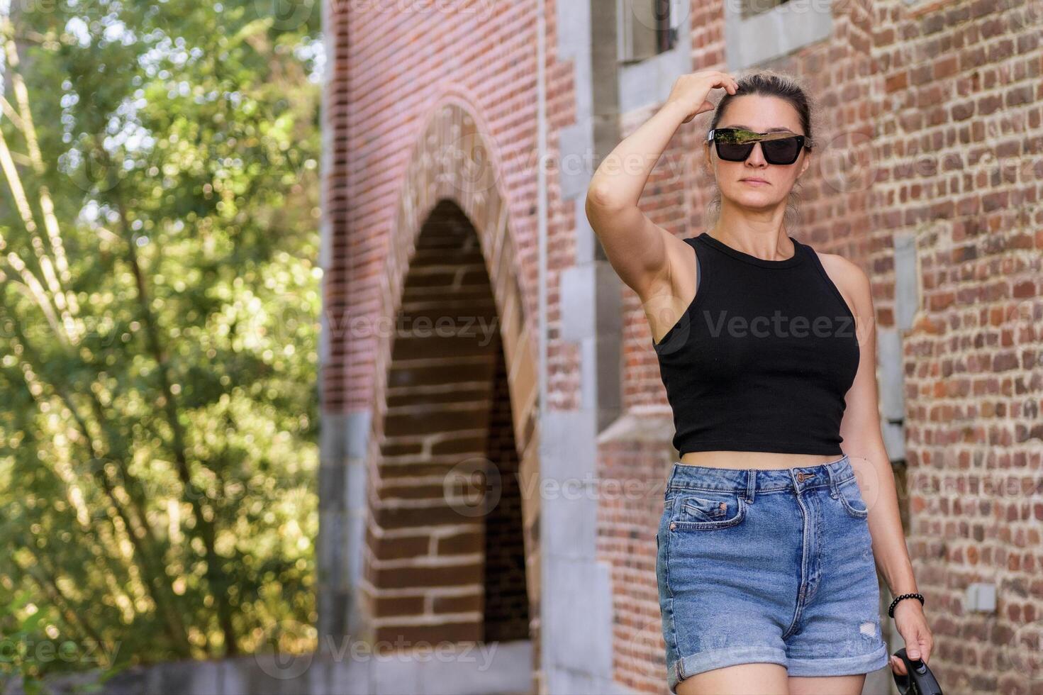 A young lady on a walk in a summer park against the backdrop of ancient architecture. copy space on the left photo