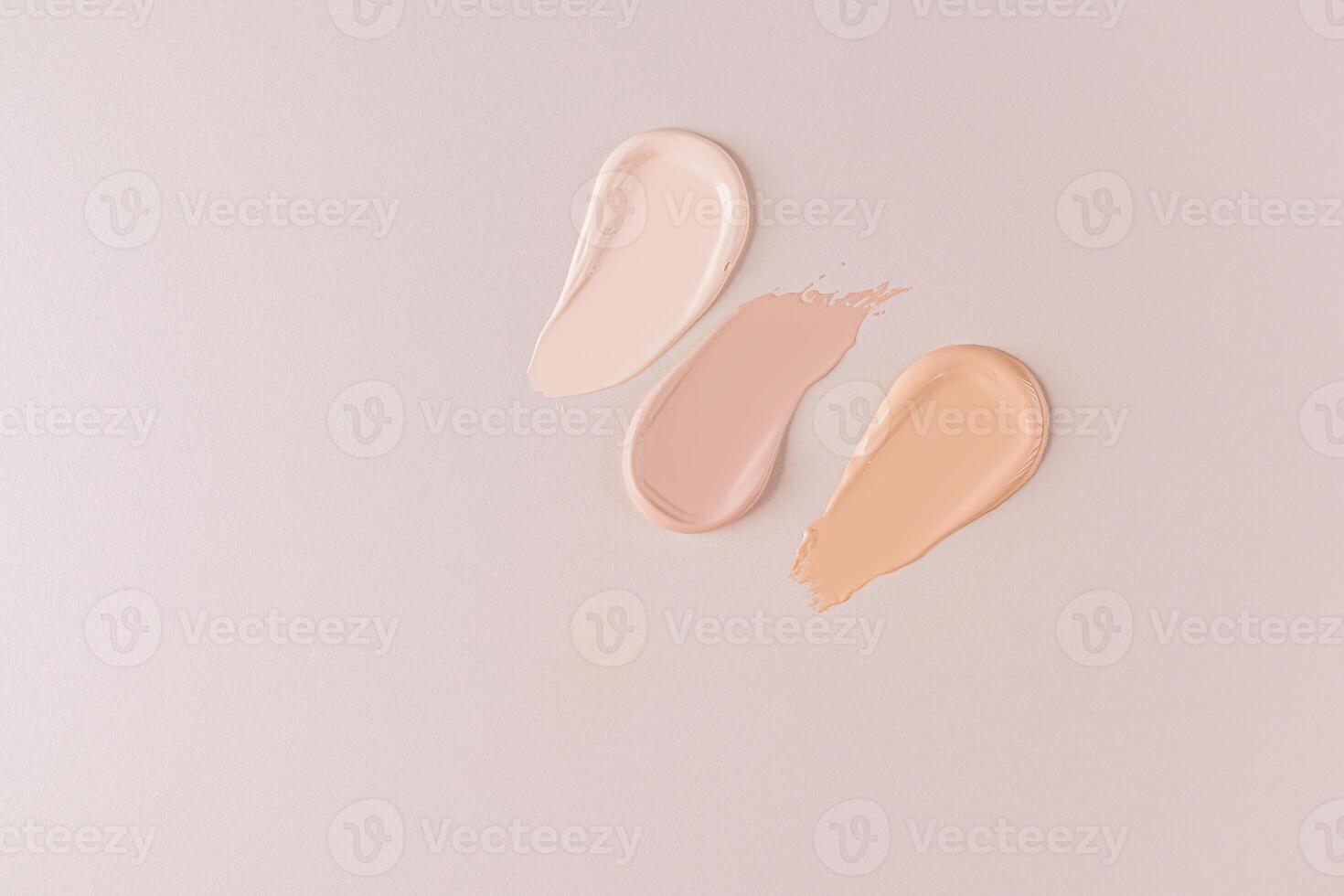 Three beautiful samples of foundation powder of different tones on a beige background with a copy space. Delicate texture of foundation . top view. photo