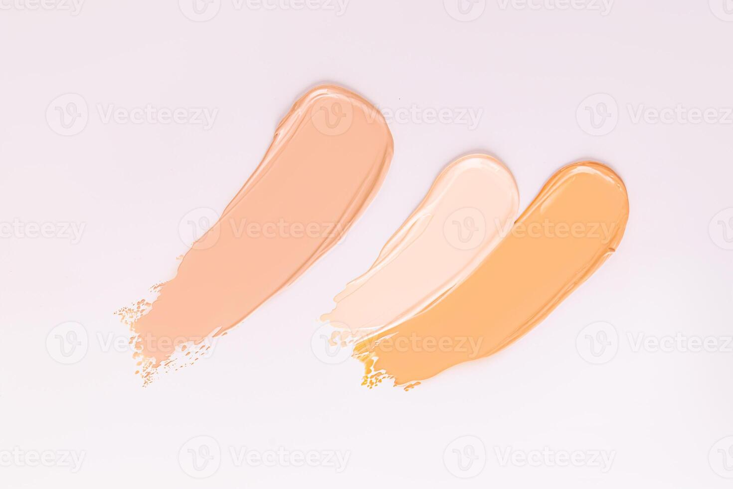 Three strokes of foundation powder of different tones on a white background. samples of the texture of the cosmetic product. Texture of foundation. photo