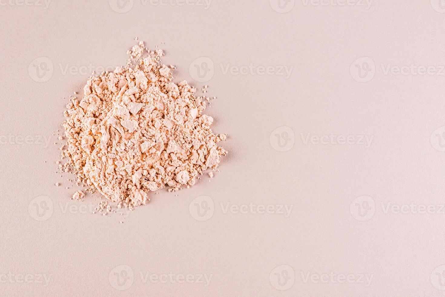 A pile of loose light powder on a beige background. space for text. layout for your product. Color cosmetics texture concept. Top view. photo