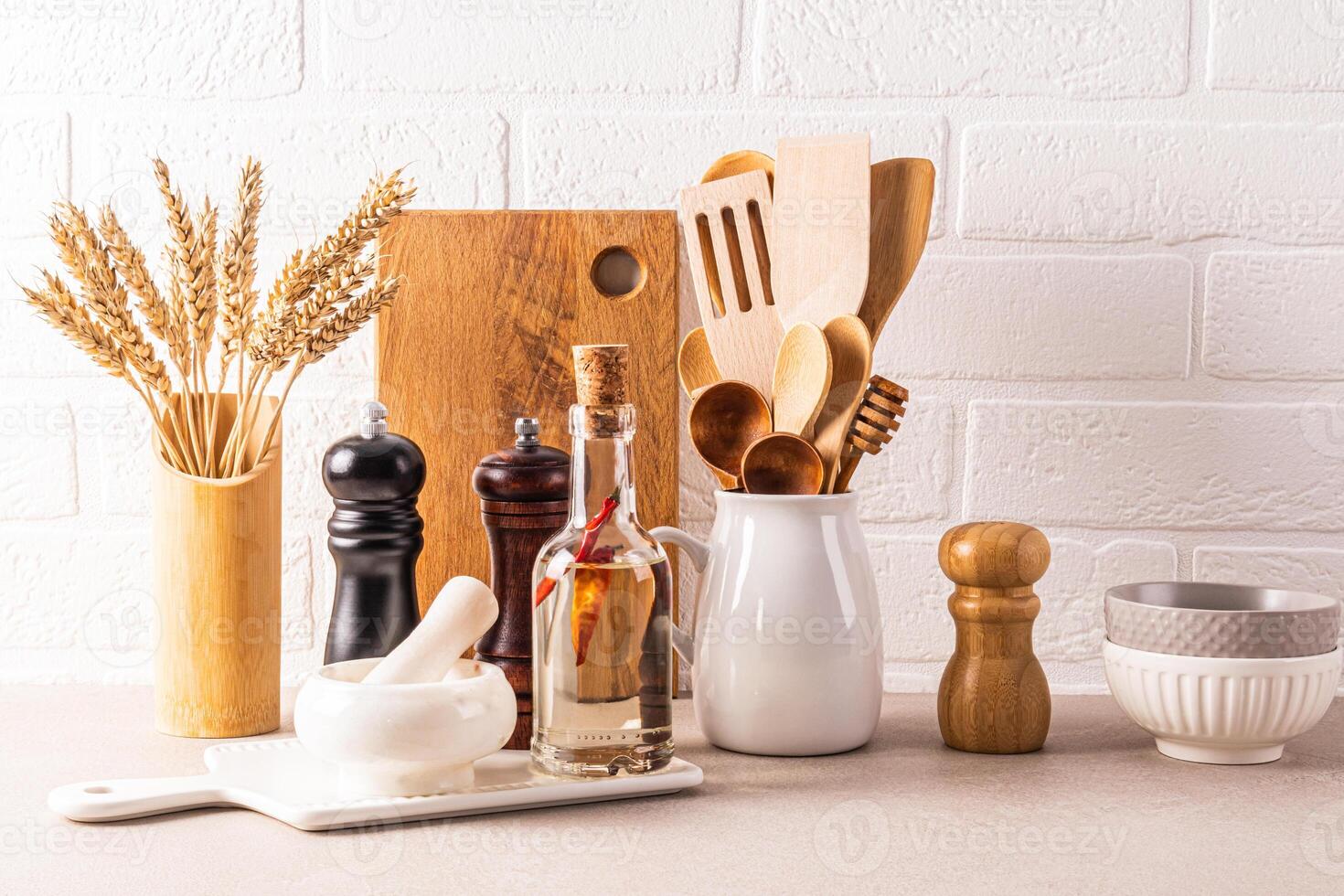 Kitchen utensils set to cook on a stone countertop against a white brick wall. Front view. Eco-friendly kitchen. Stylish kitchen background. photo